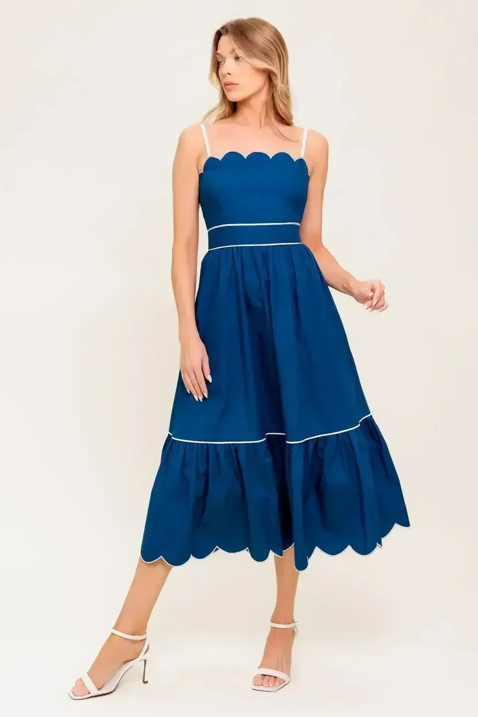 Navy midi dress with a scalloped neckline, sleeve straps, and a ruffled hemline