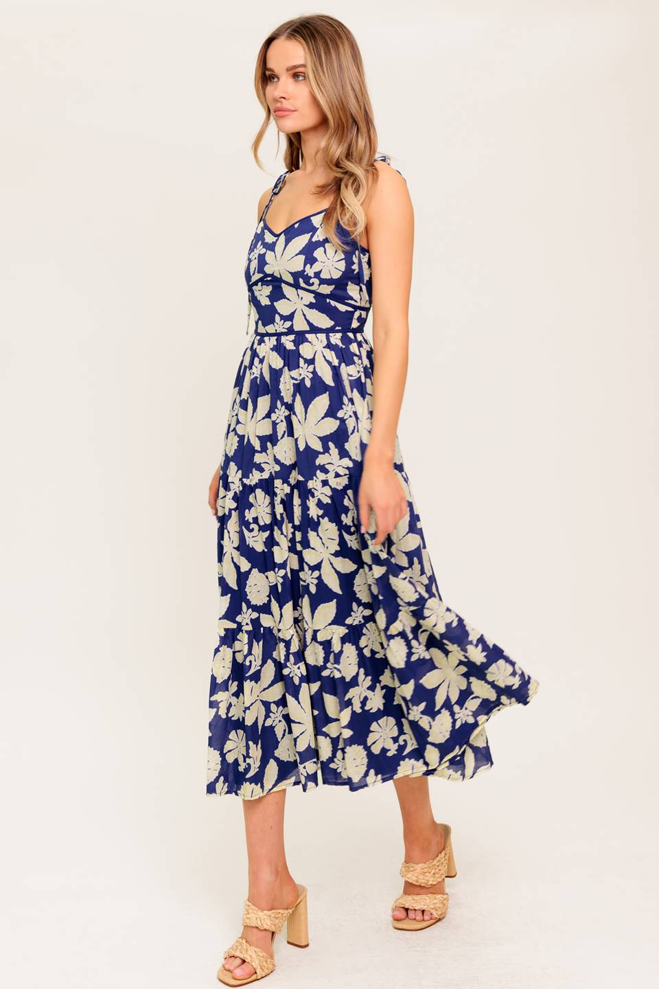 Blue floral midi dress with a sweetheart neckline, shoulder tie, waist yoke, tiered skirt, and back zipper closure.