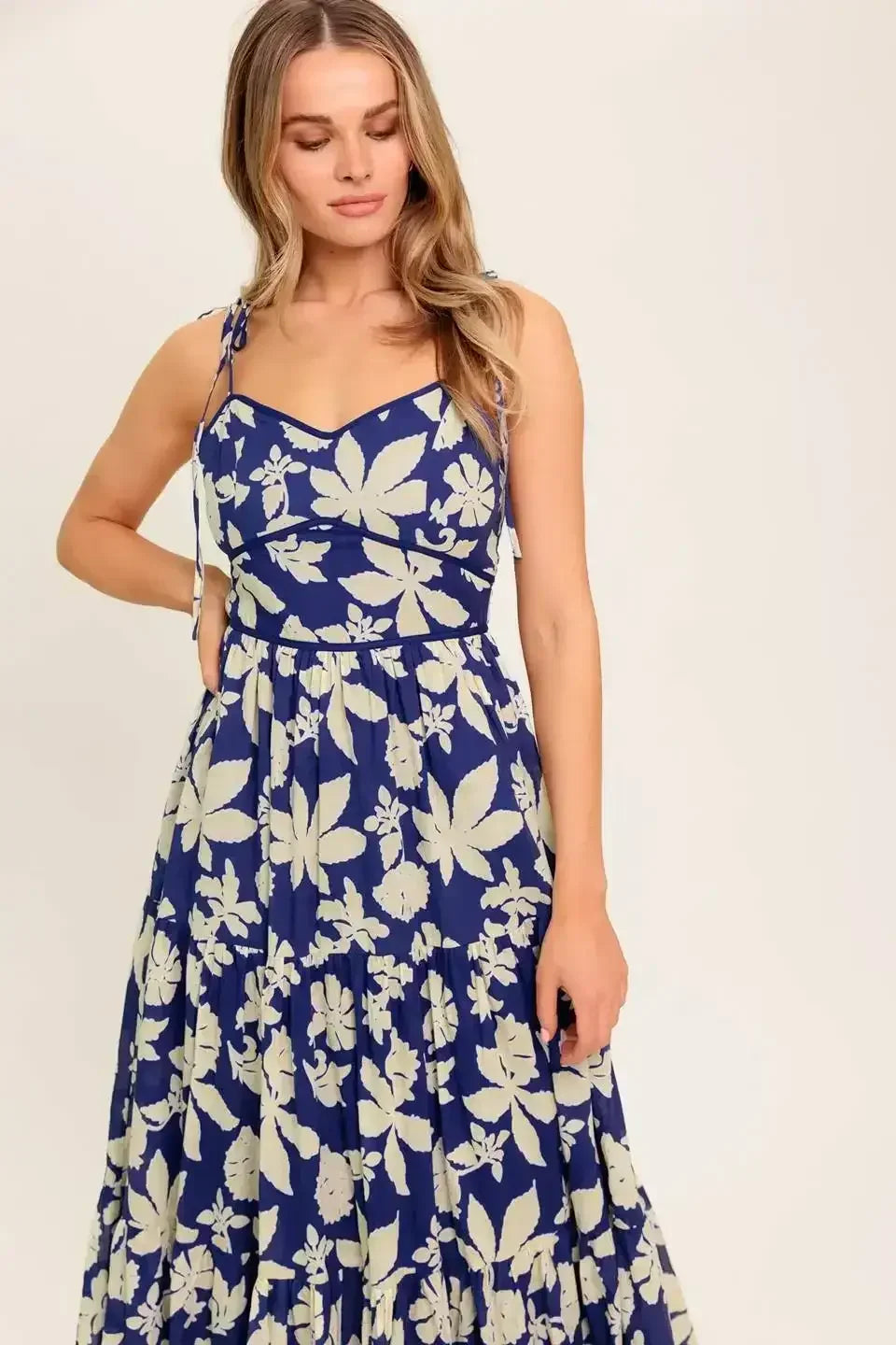Blue floral midi dress with a sweetheart neckline, shoulder tie, waist yoke, tiered skirt, and back zipper closure.
