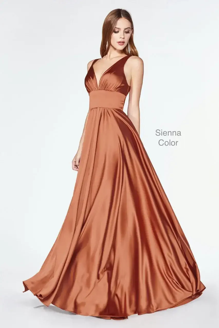 A flowing, sienna-colored satin gown elegantly drapes around a model. The dress features a deep V-neck and wide straps, enhancing the figure against a light background.