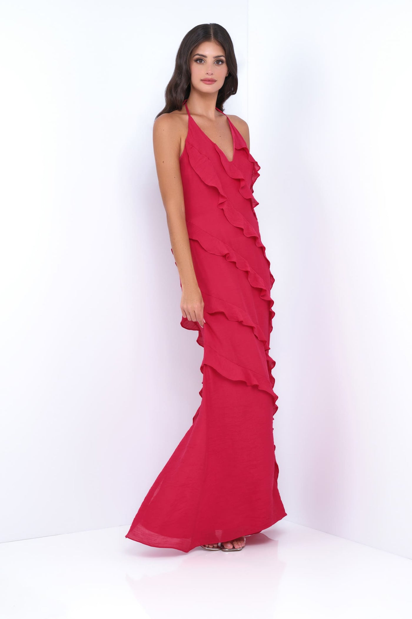 Woman wearing a red ruffled evening gown on a white background