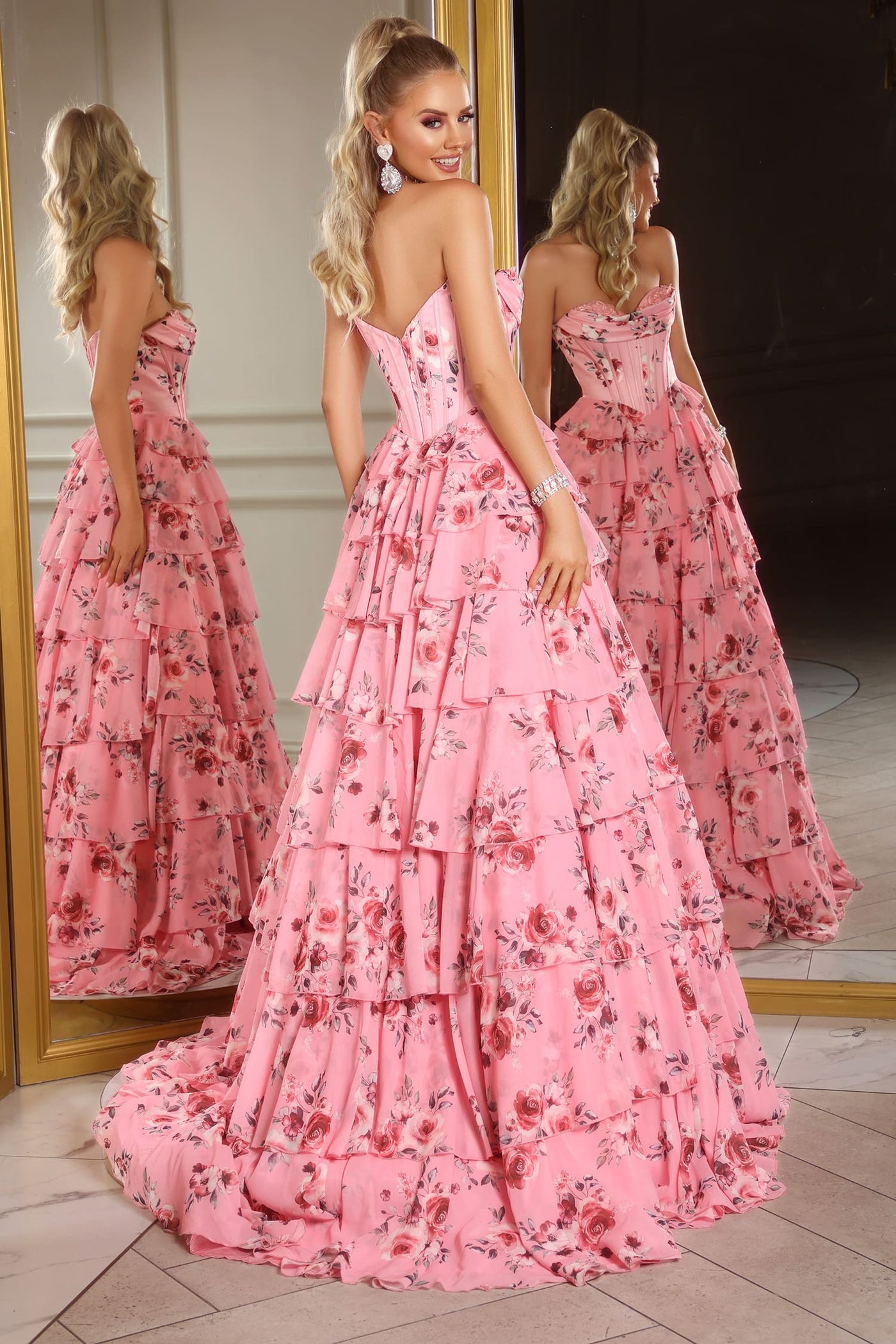 Woman in a pink floral dress standing in front of a mirror.
