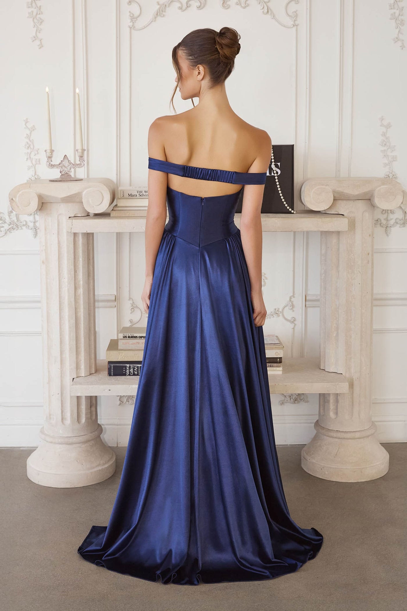 Woman wearing a blue evening gown in an elegant room setting.