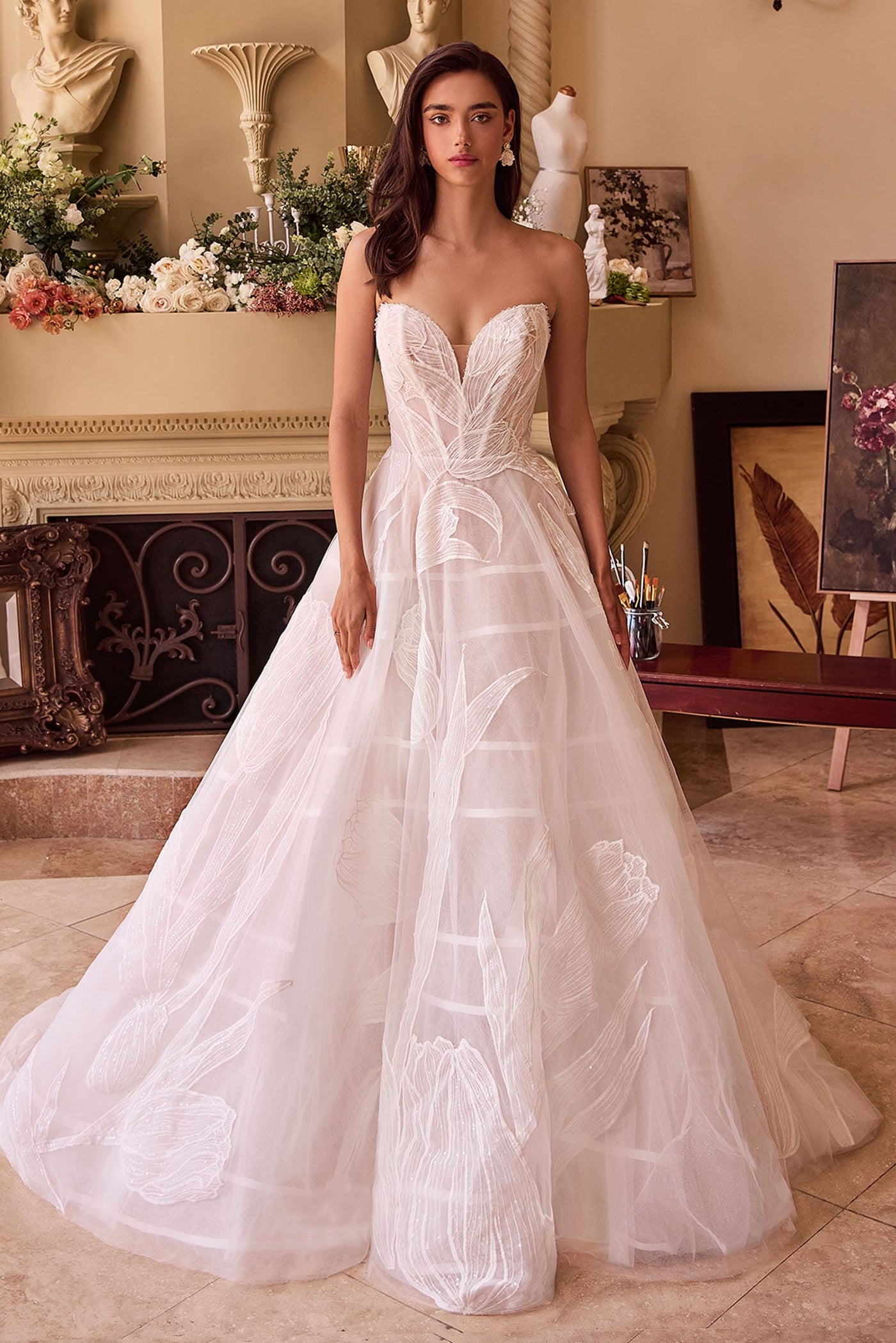 Woman wearing a strapless white wedding dress in an elegant indoor setting.