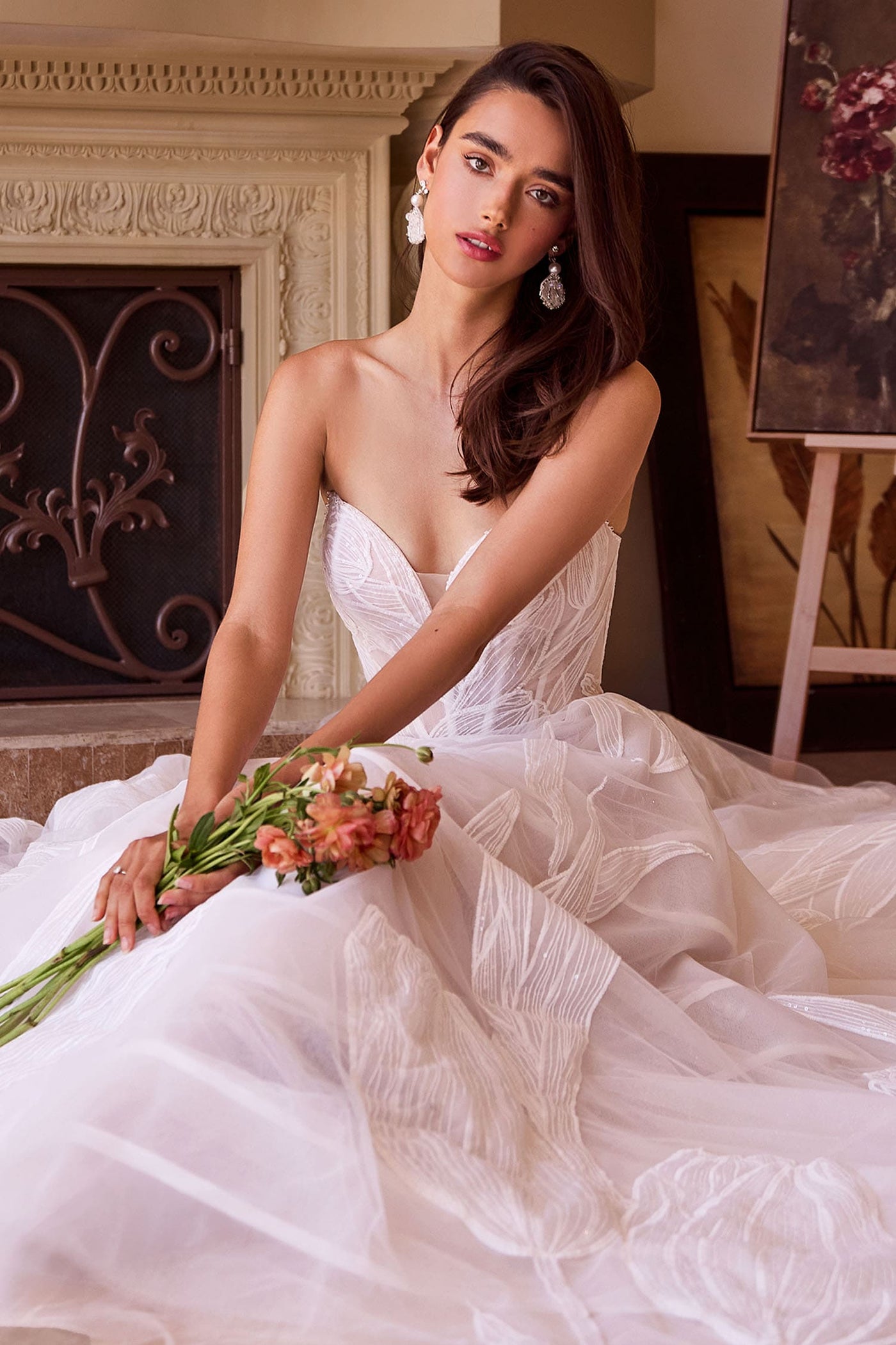 Woman in a white wedding dress holding flowers in an elegant indoor setting.