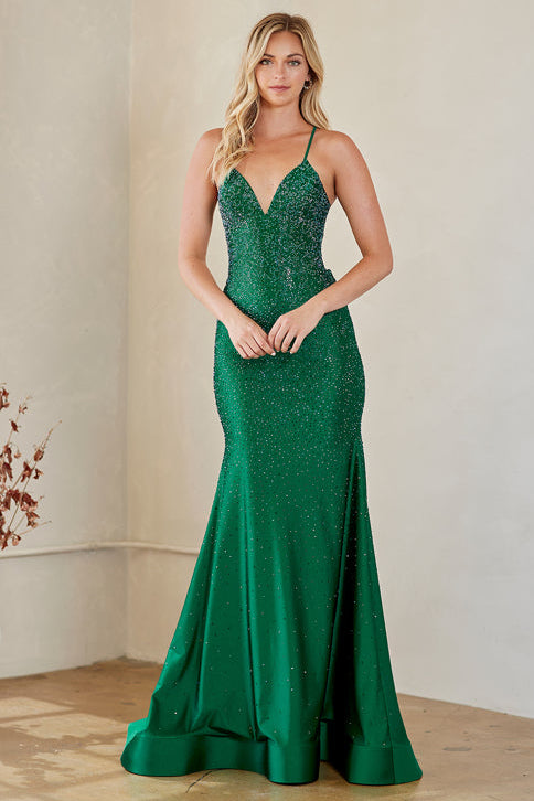 Woman wearing a green evening gown with a plain background