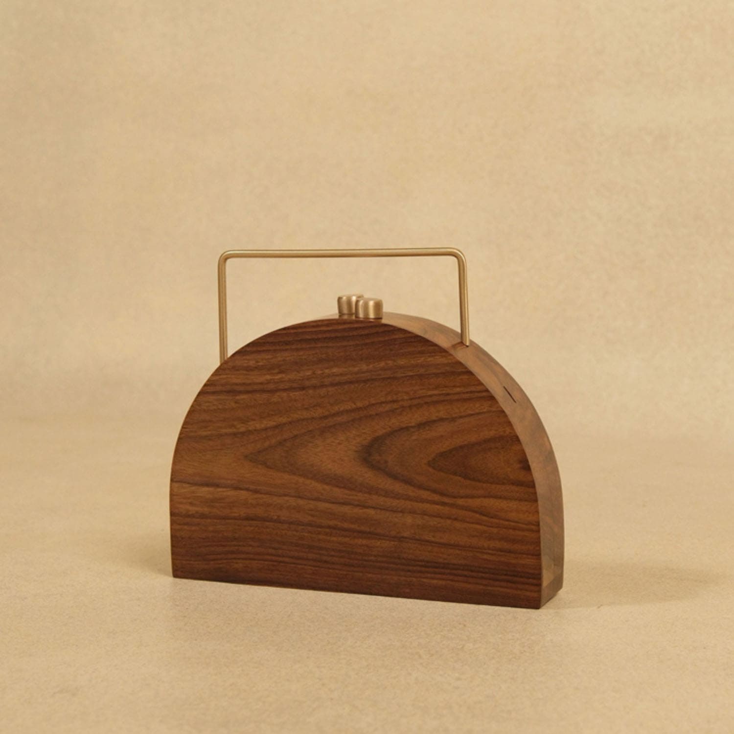 Wooden handbag with a gold handle on a beige background