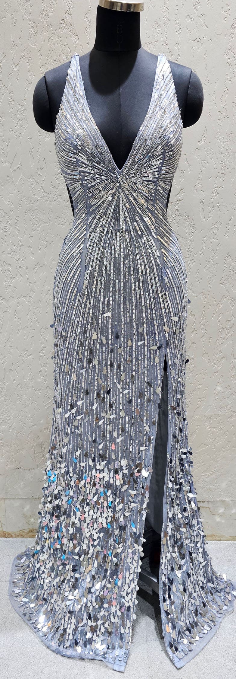 Silver beaded evening gown on a mannequin against a neutral background