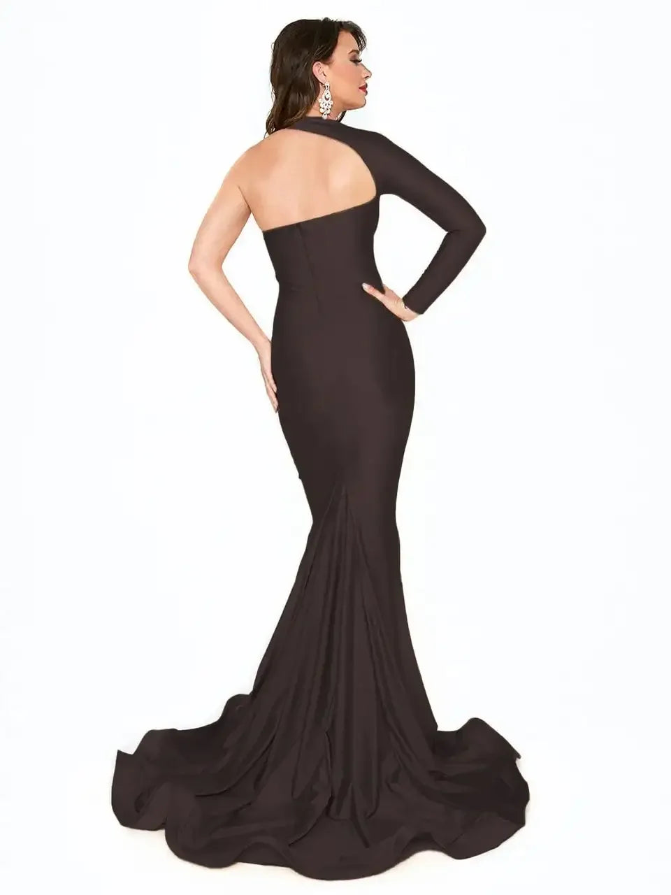 A woman wears a form-fitting, elegant black gown with one shoulder exposed and a long train. She poses with her back facing the viewer, showcasing the dress's sleek design against a white background.