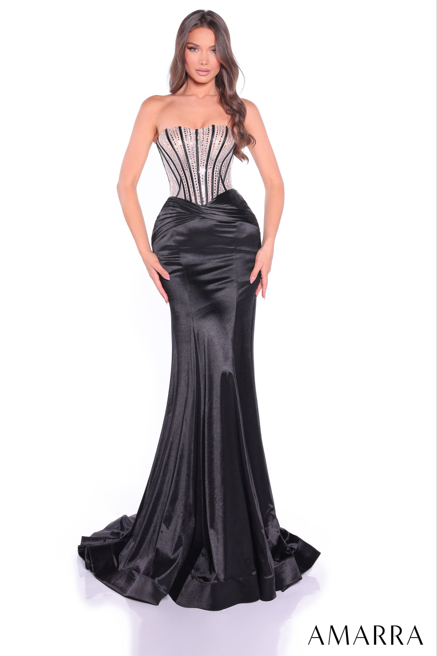 Woman wearing a black strapless gown with silver detailing on a white background, brand 'AMARRA' visible.