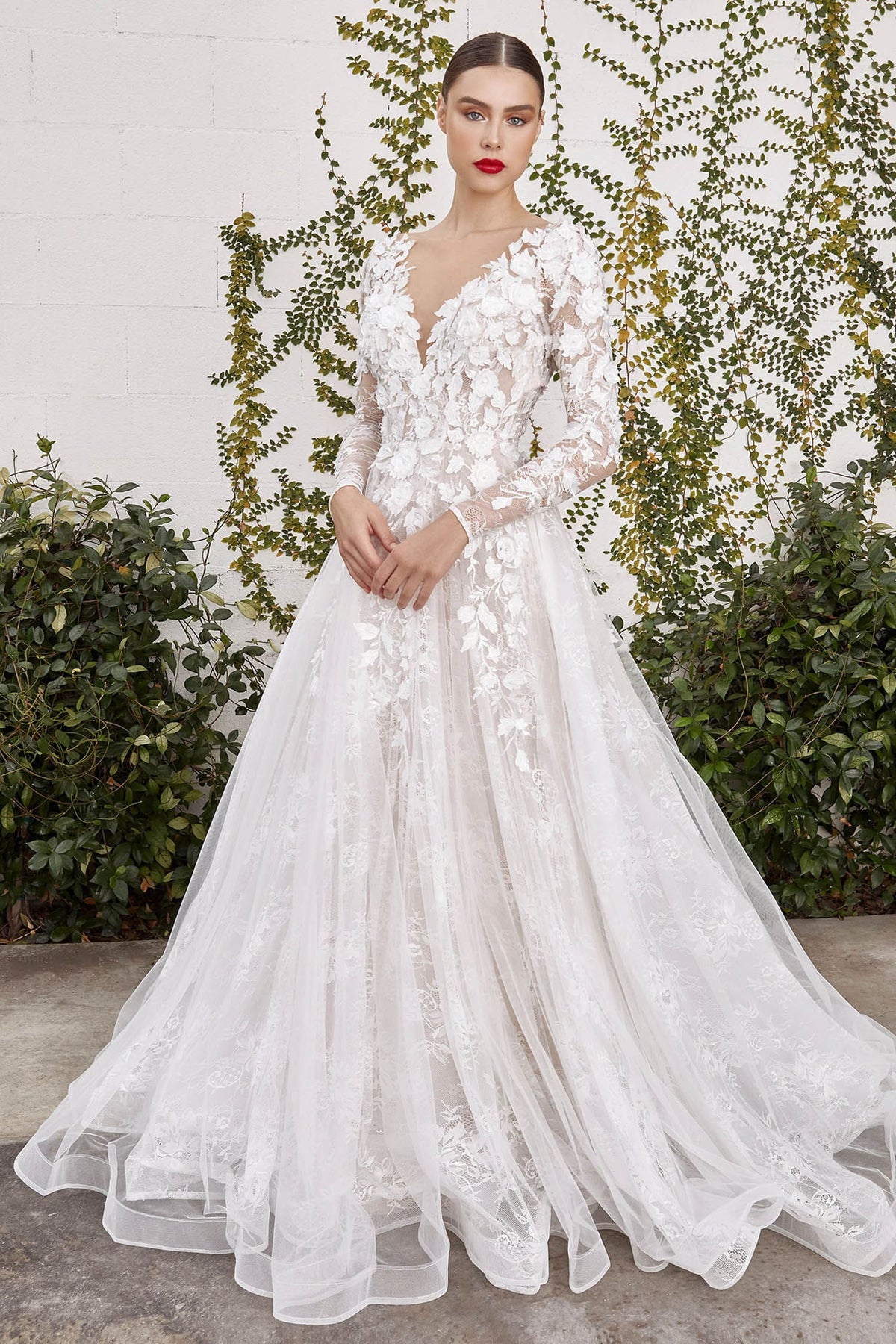 Woman wearing a white floral wedding dress against a natural background