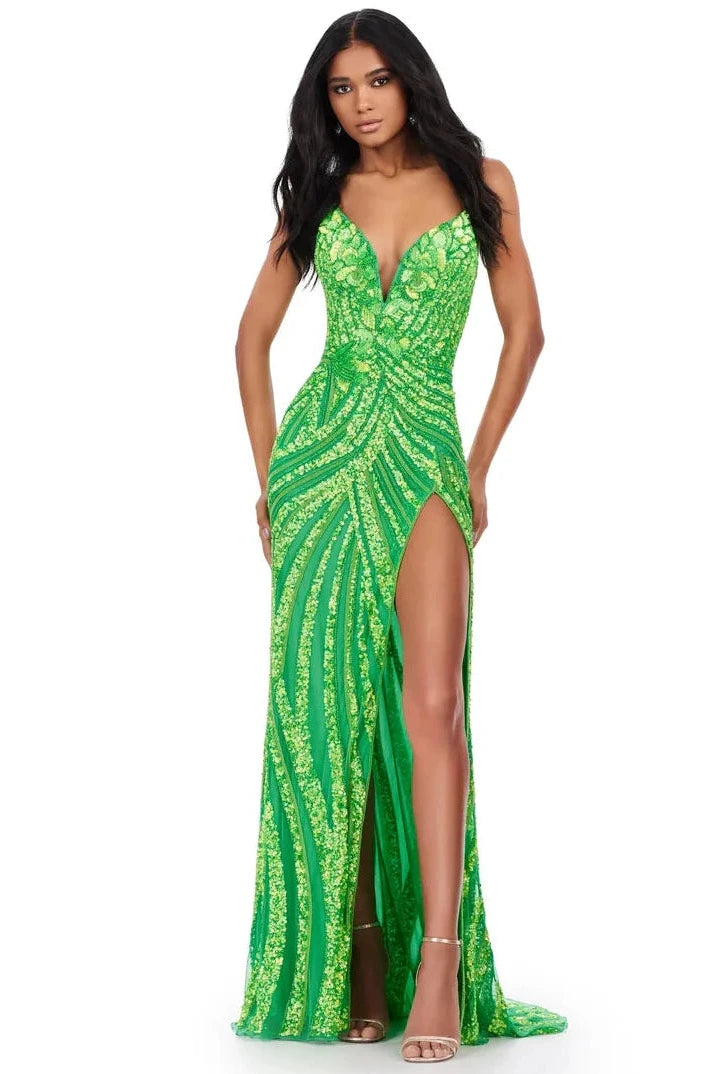 Woman wearing a green beaded evening gown with a slit on a white background