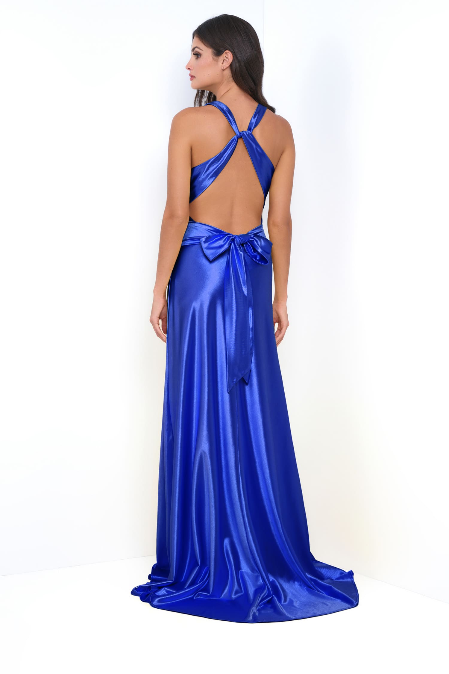 Woman wearing a blue satin evening gown with a bow detail on a white background