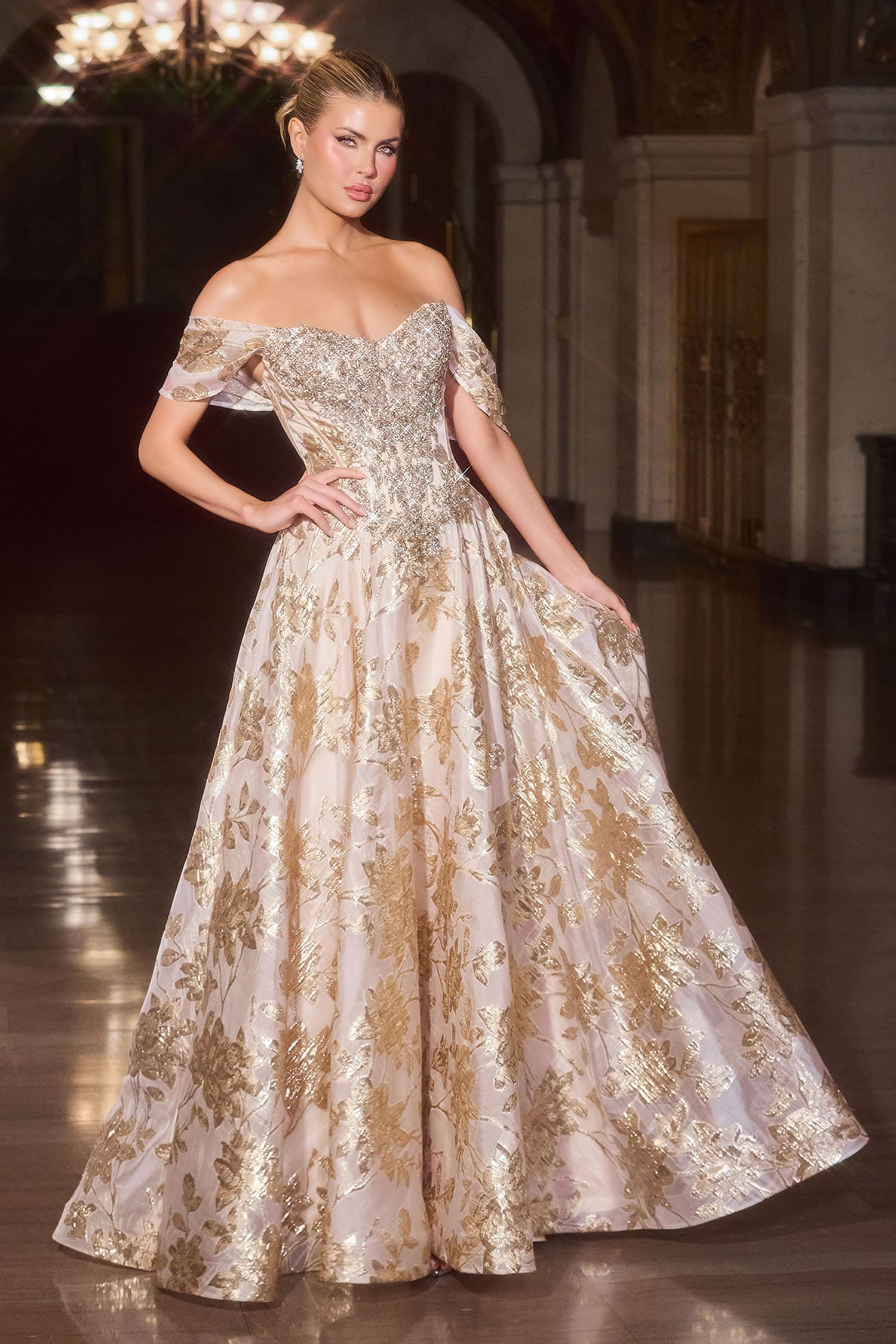 Woman wearing a gold and white evening gown in an elegant indoor setting