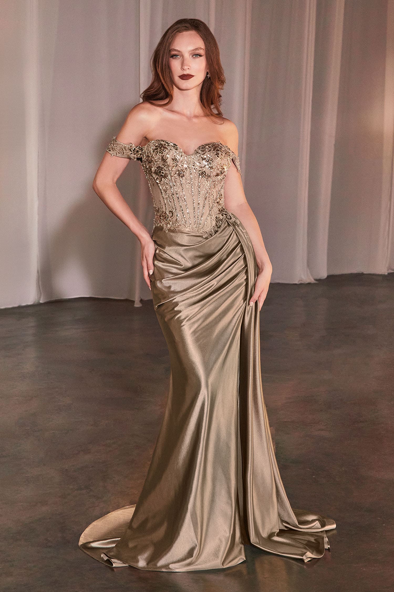 Woman wearing a glamorous evening gown with a metallic finish against a neutral background