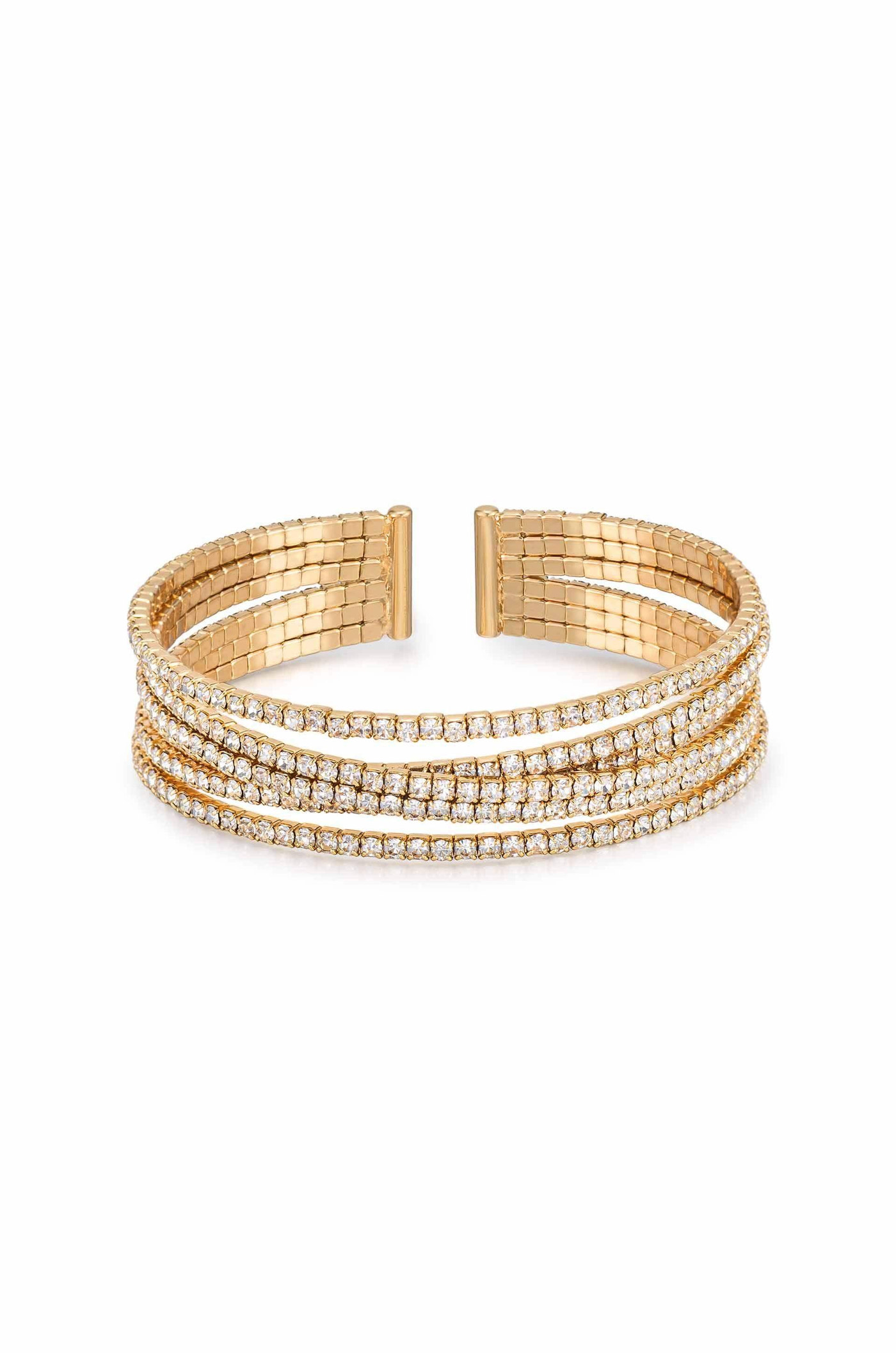 A gold cuff bracelet featuring three intertwined strands, adorned with sparkling clear gemstones. It rests against a plain white background, emphasizing its elegant design and glimmering accents.
