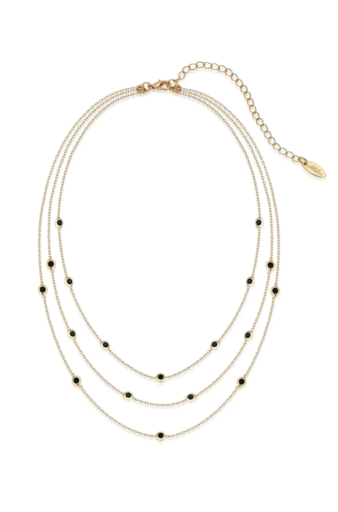 A layered gold necklace features multiple delicate chains adorned with small black embellishments, elegantly displaying a combination of shine and contrast in a clean, white background setting.