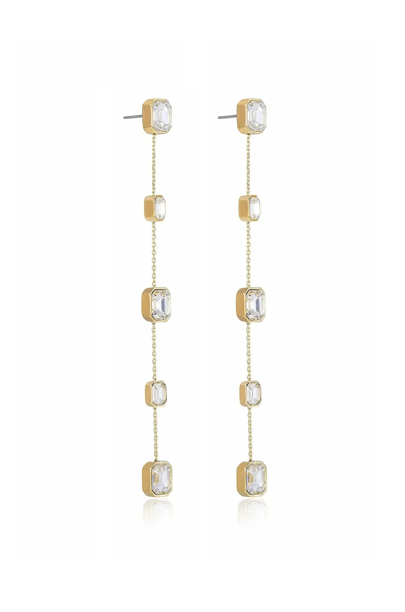 Dangling earrings feature a gold-tone design with multiple clear crystalline stones arranged vertically. They hang elegantly, reflecting light against a plain white background, emphasizing their delicate appearance.