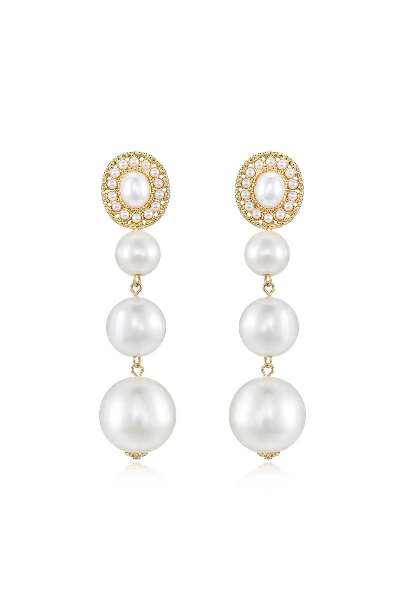 Elegant dangle earrings feature a cluster of four cascading white pearls, topped with a round, bejeweled gold setting. They reflect light, suggesting a formal or luxurious context.