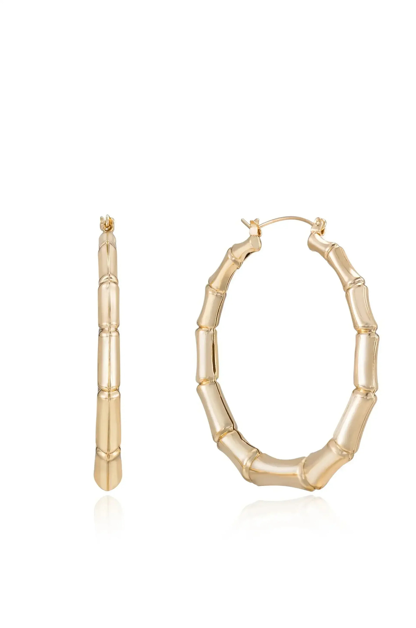 Golden hoop earrings shaped like bamboo stalks are displayed prominently. One earring is upright, showing its profile, while the other is angled, revealing its dimensional design against a reflective surface.
