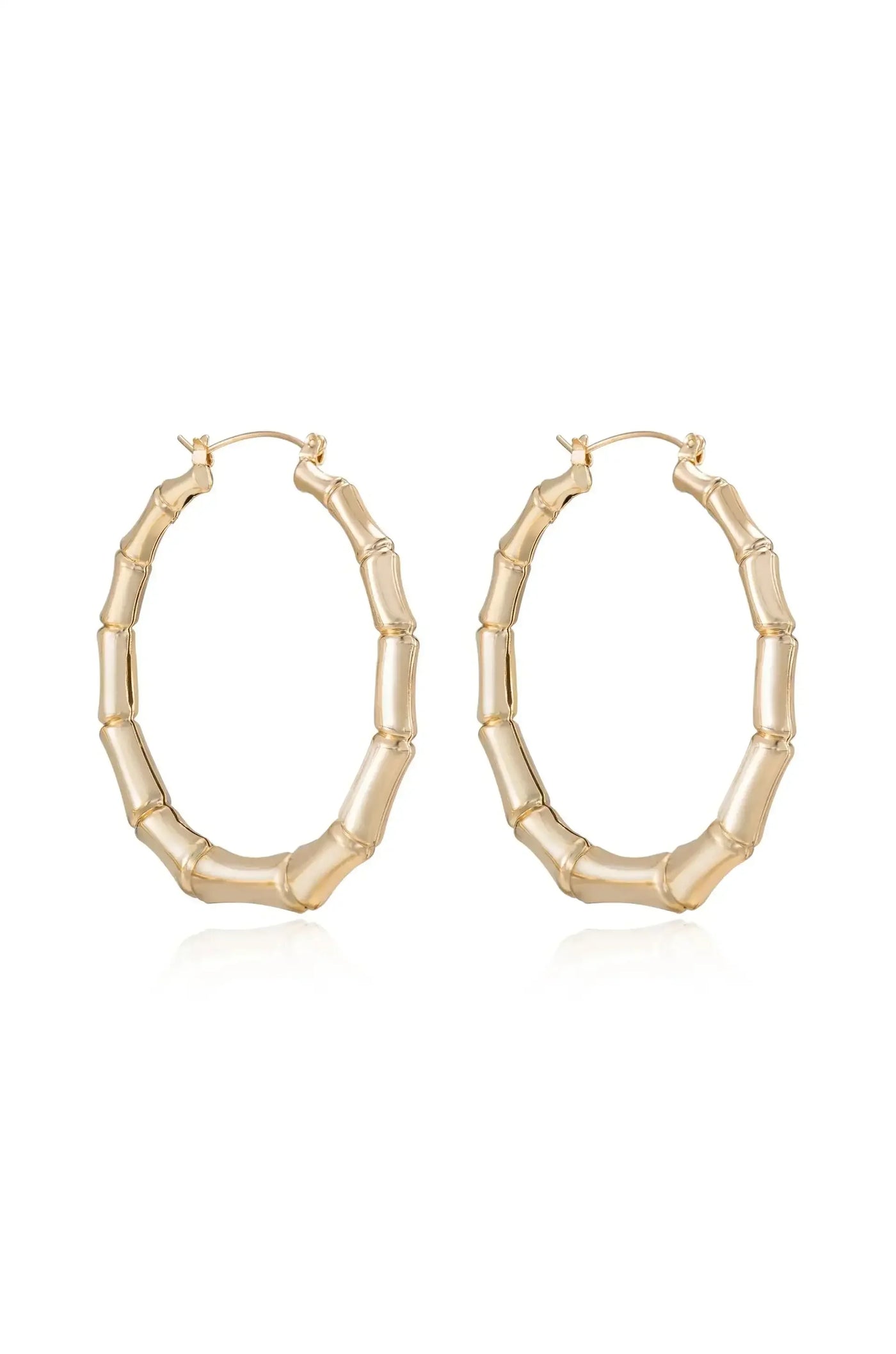 Gold hoop earrings feature a bamboo-inspired design. They hang from a small clasp and reflect light, set against a plain white background, emphasizing their shine and elegance.