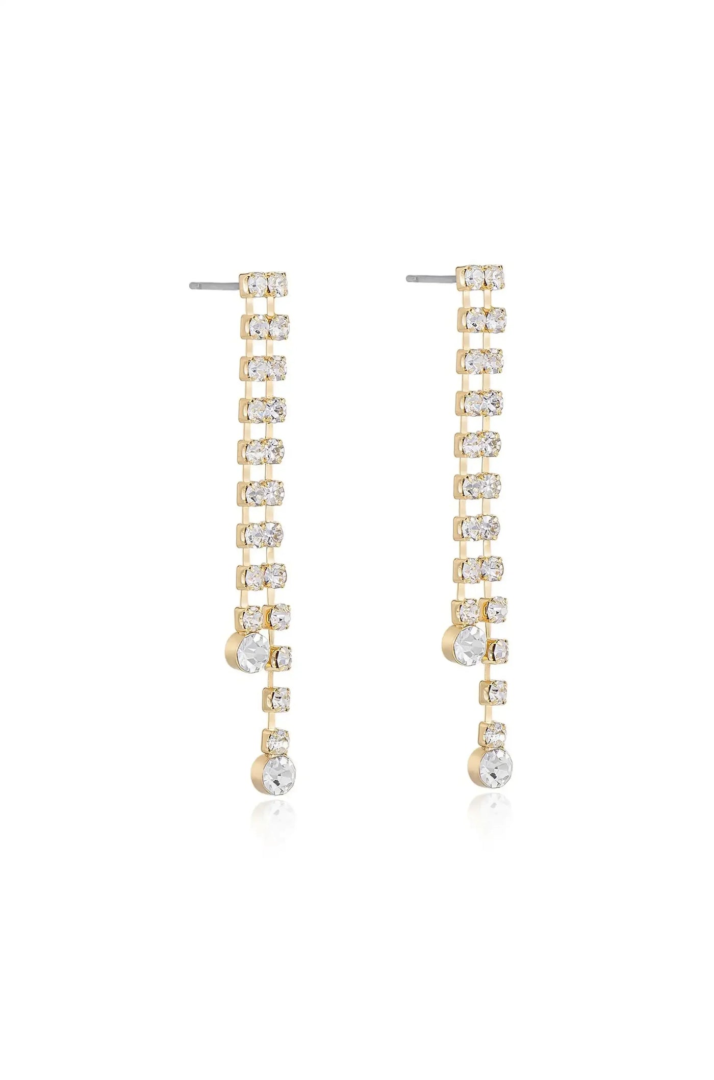 Gold earrings adorned with sparkling crystals hang vertically. They feature a linear design, leading to larger crystals at the end, reflecting light in a bright, elegant display.