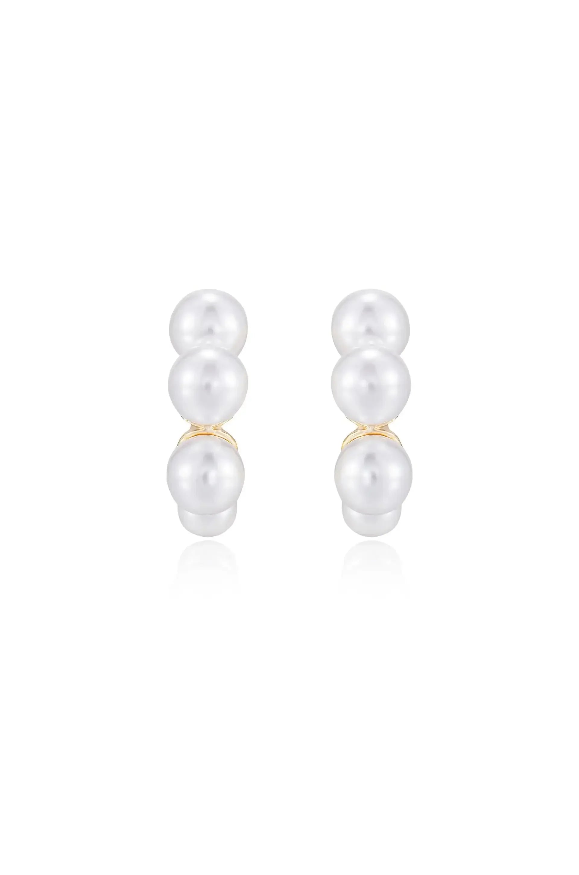 Two pairs of pearl earrings are displayed, showcasing three smooth, shiny pearls stacked vertically. The earrings reflect light against a simple, white background, highlighting their elegance.