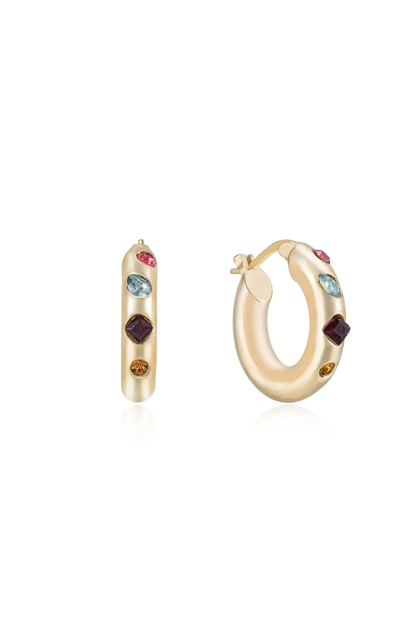 Colorful hoop earrings are displayed, one upright and one tilted, showcasing various gemstones embedded in a gold-hued metal, against a soft, reflective surface.