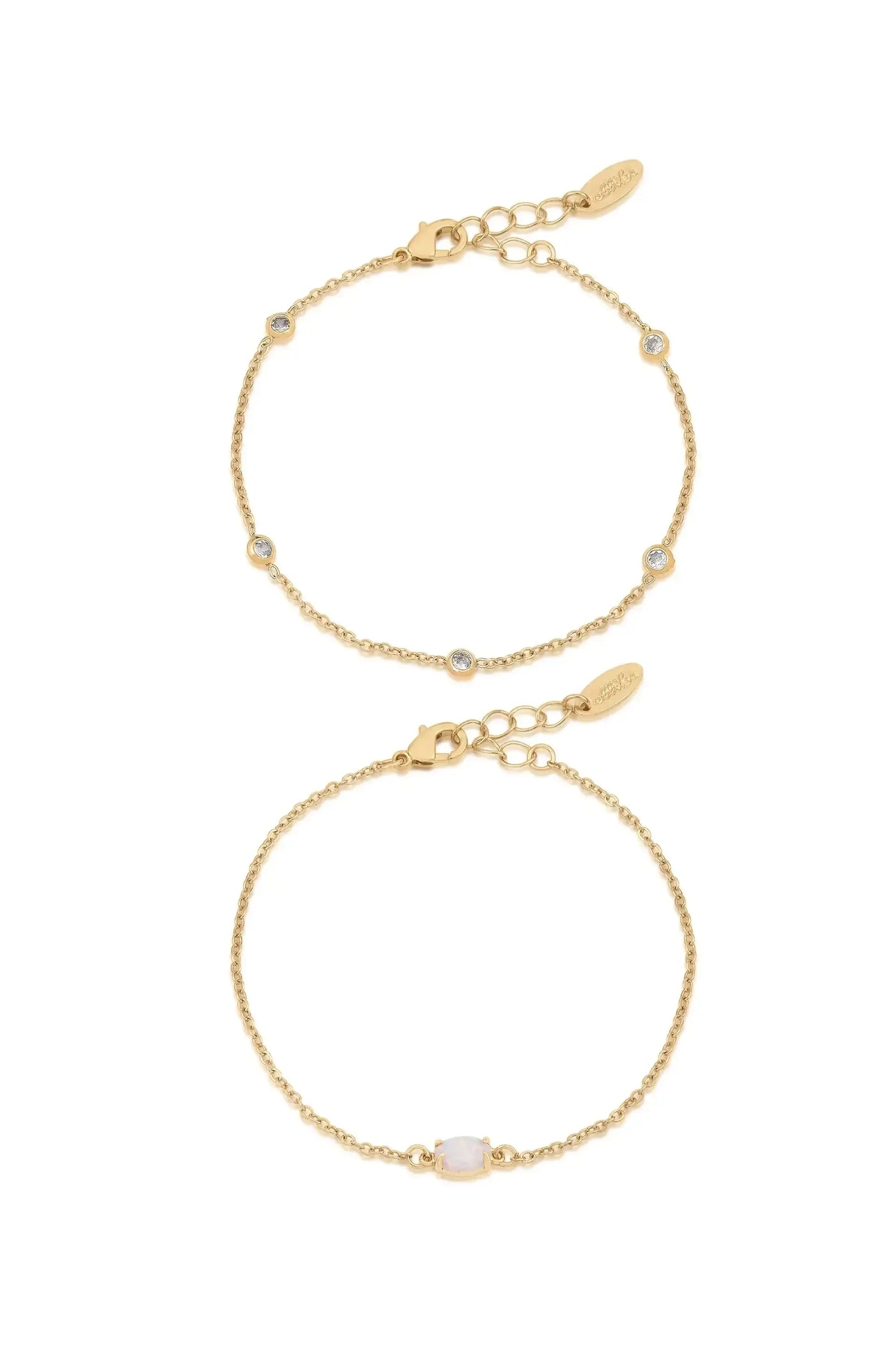 Two delicate gold bracelets are displayed. One features small round stones along the chain, while the other has a larger, oval stone centered. Both have adjustable clasps.