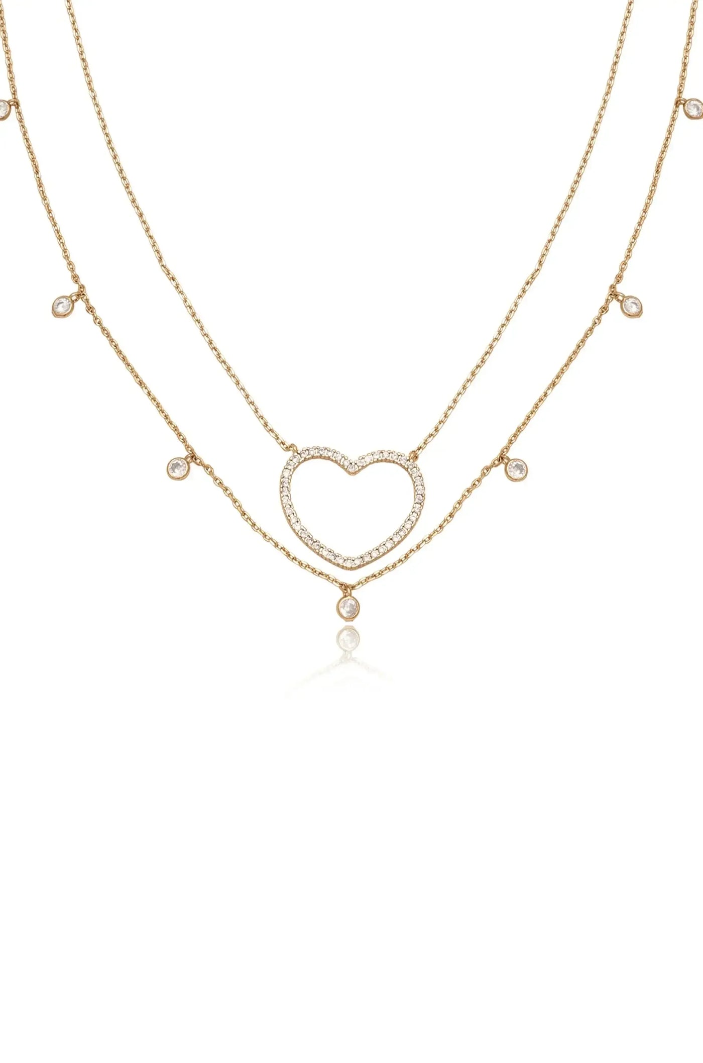 A delicate gold necklace with two layered chains features a heart-shaped pendant adorned with sparkling stones. The design exudes elegance against a plain white background.