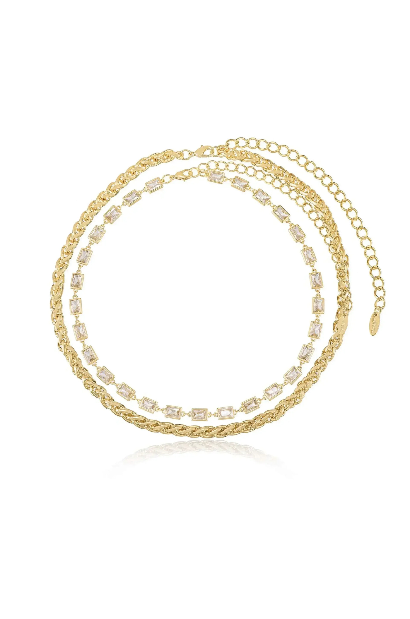 A layered gold necklace features intricate chain designs and decorative clear rectangular stones. It is displayed against a plain white background, highlighting its shimmering details and elegant style.