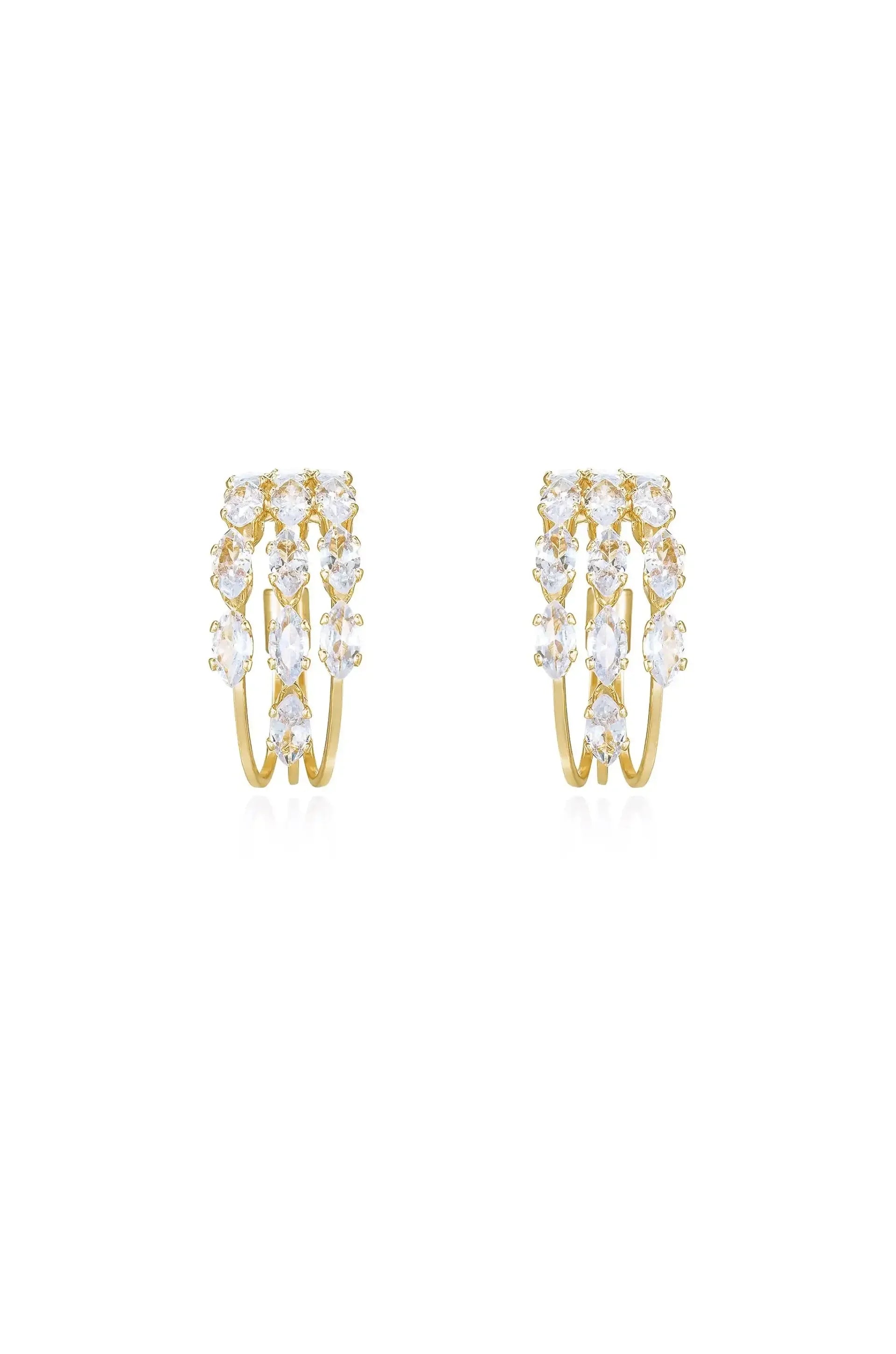 Gold hoop earrings adorned with multiple sparkling gemstones arranged in a cascading pattern, positioned against a clean, white background, showcasing their elegance and shine.