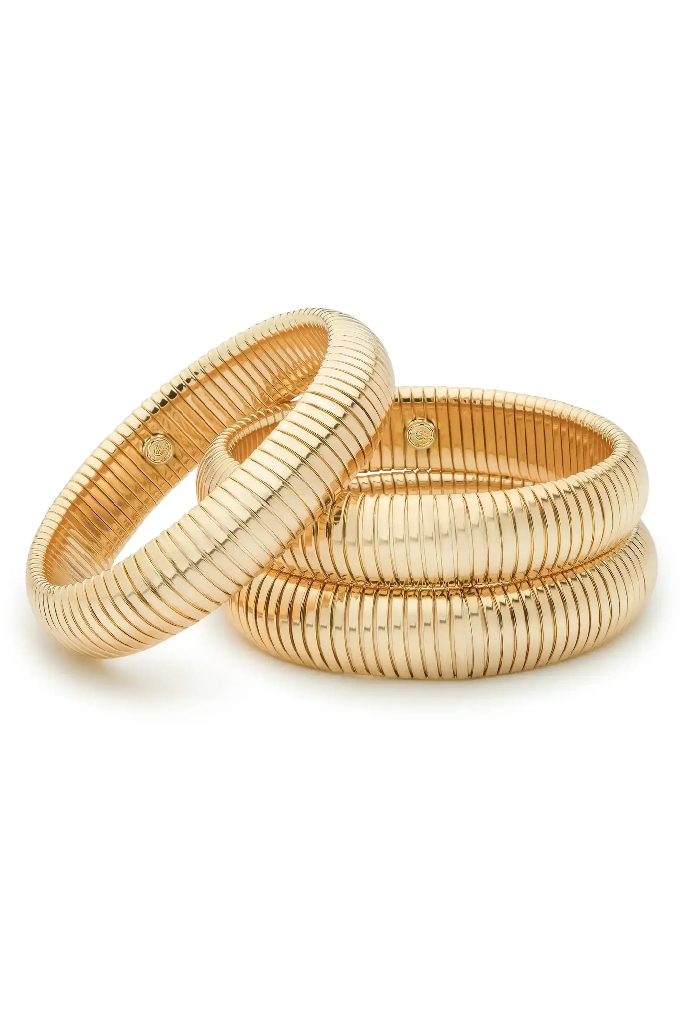 Three gold bangles are overlapping, showcasing their smooth, ribbed surfaces and reflective quality, set against a plain white background that highlights their elegant design.