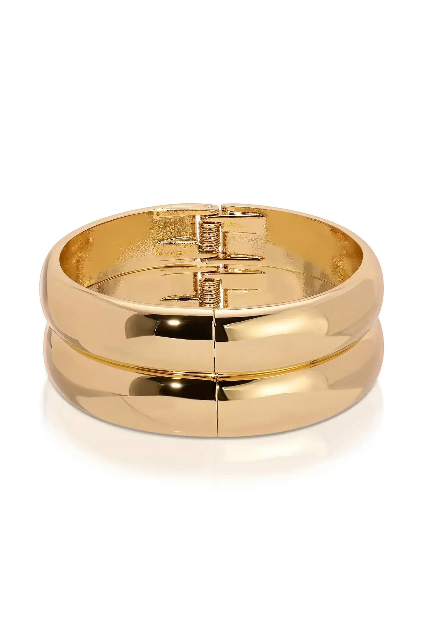 A gold bangle bracelet sits on a smooth surface, showcasing its shiny, reflective surface. The design features a hinge mechanism for easy opening and closing, emphasizing its sleek appearance.