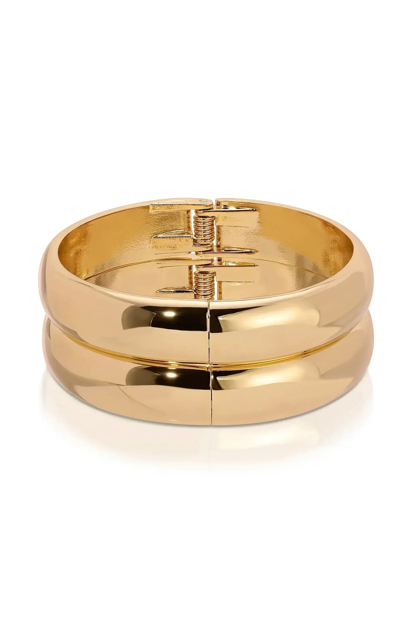 A gold bangle bracelet sits on a smooth surface, showcasing its shiny, reflective surface. The design features a hinge mechanism for easy opening and closing, emphasizing its sleek appearance.