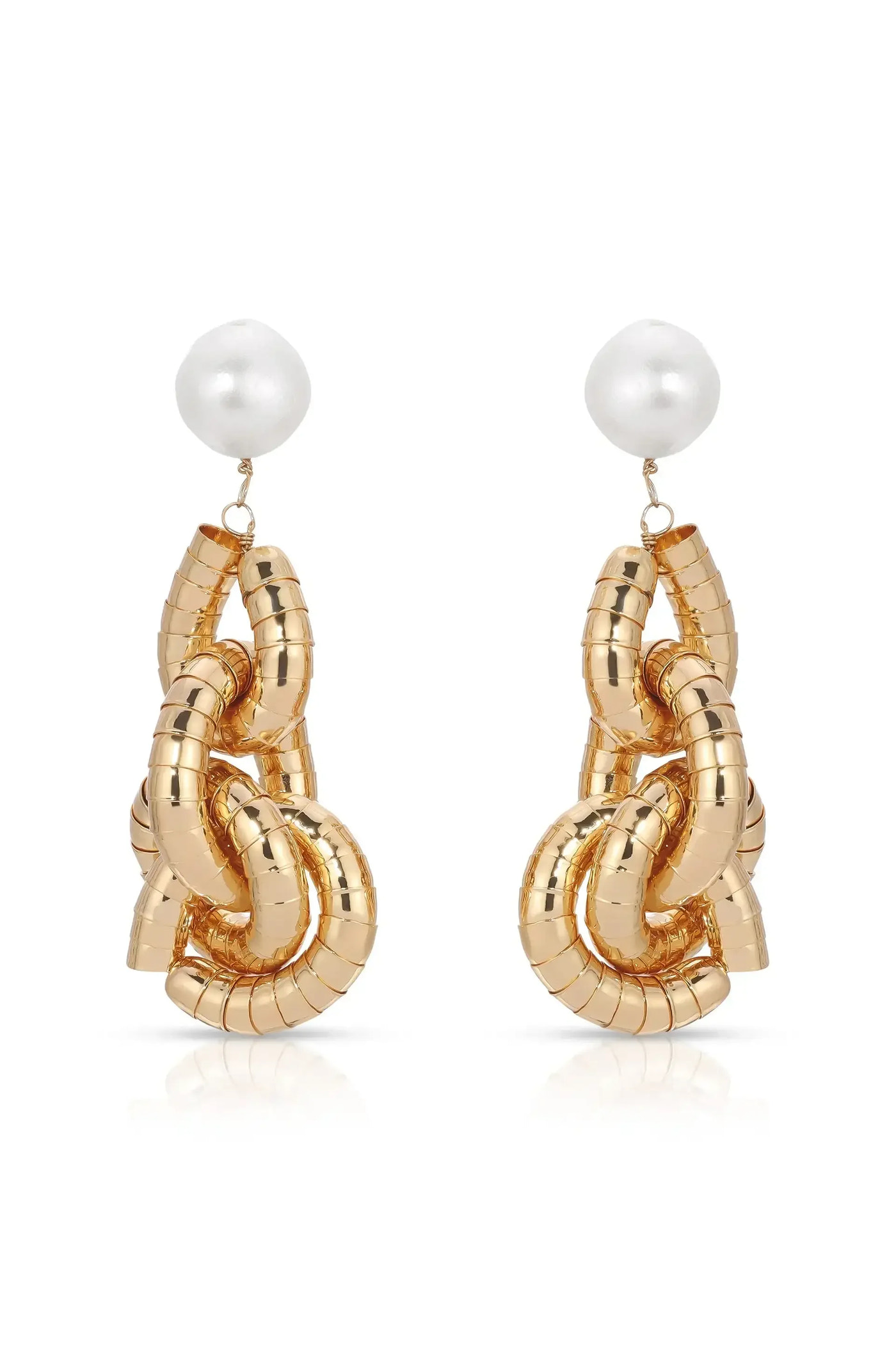 Two gold-colored earrings shaped like intertwined links feature a shiny white spherical bead at the top. They are displayed against a reflective background.