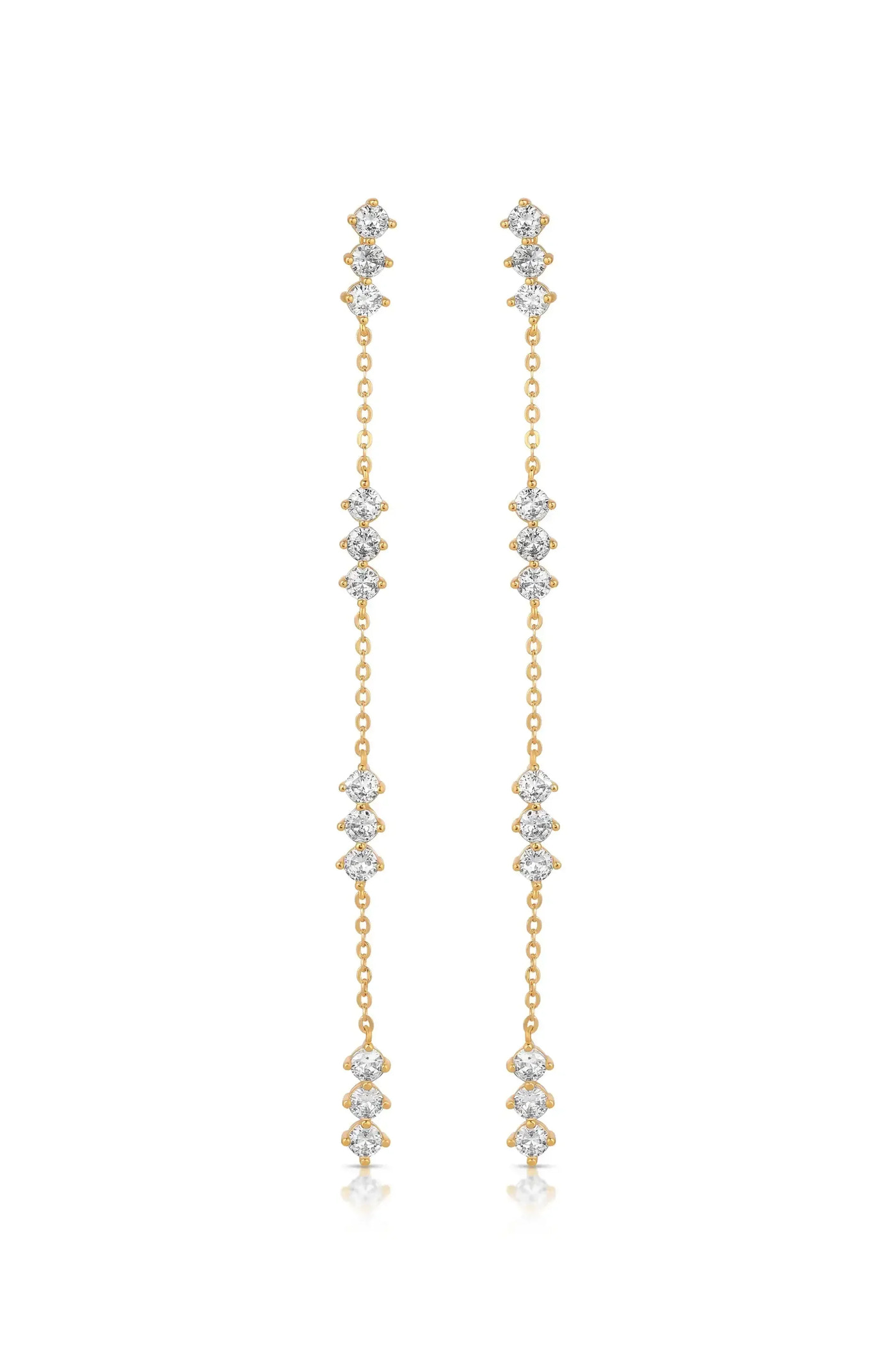 Dangling earrings made of gold feature multiple interconnected diamond-like gemstones, creating a shimmering effect against a clean, neutral background. The design emphasizes elegance and sophistication.