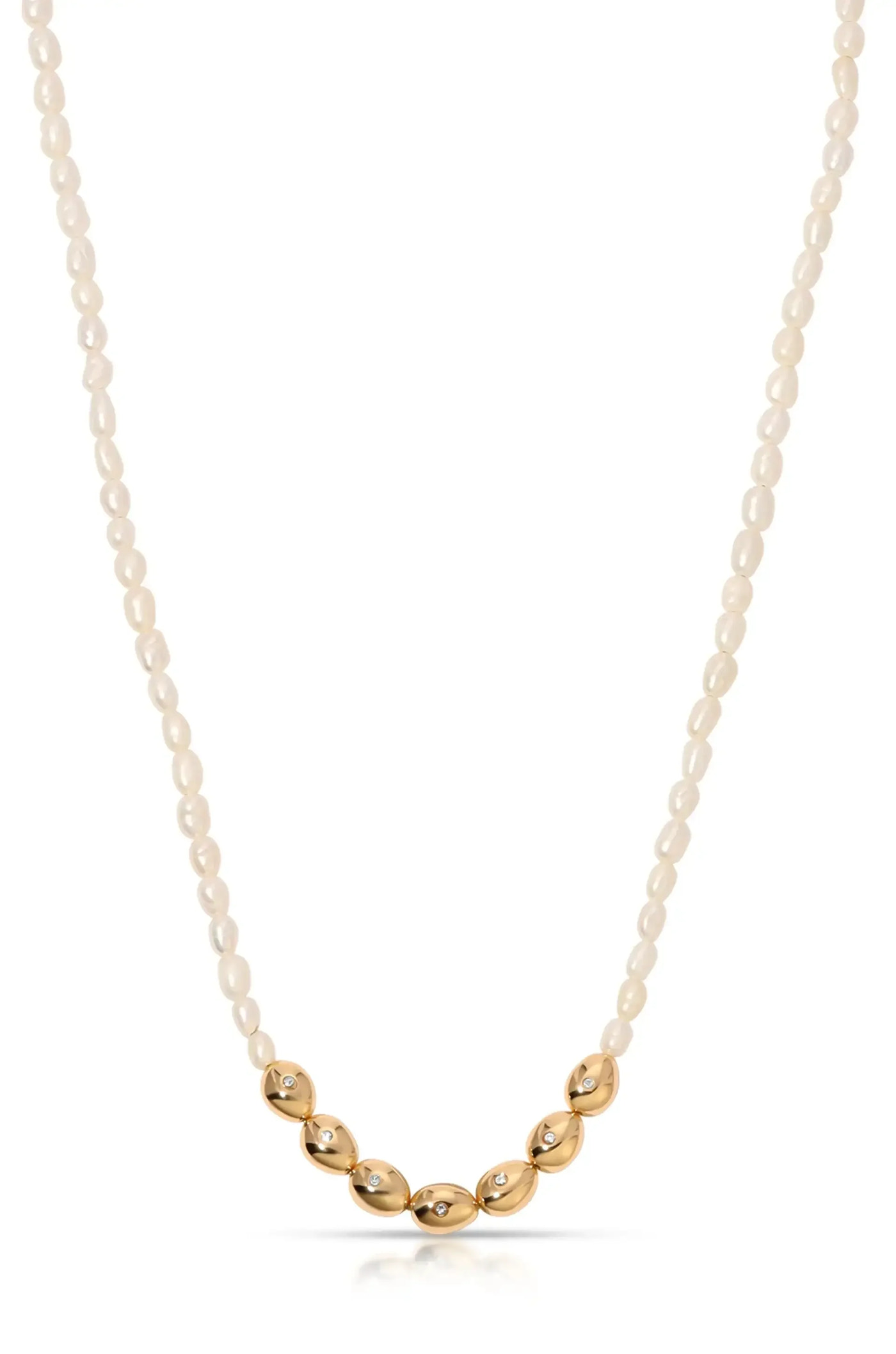 A pearl necklace combines small, glossy white pearls with larger gold oval-shaped beads, some adorned with sparkling stones, elegantly displayed against a plain background.