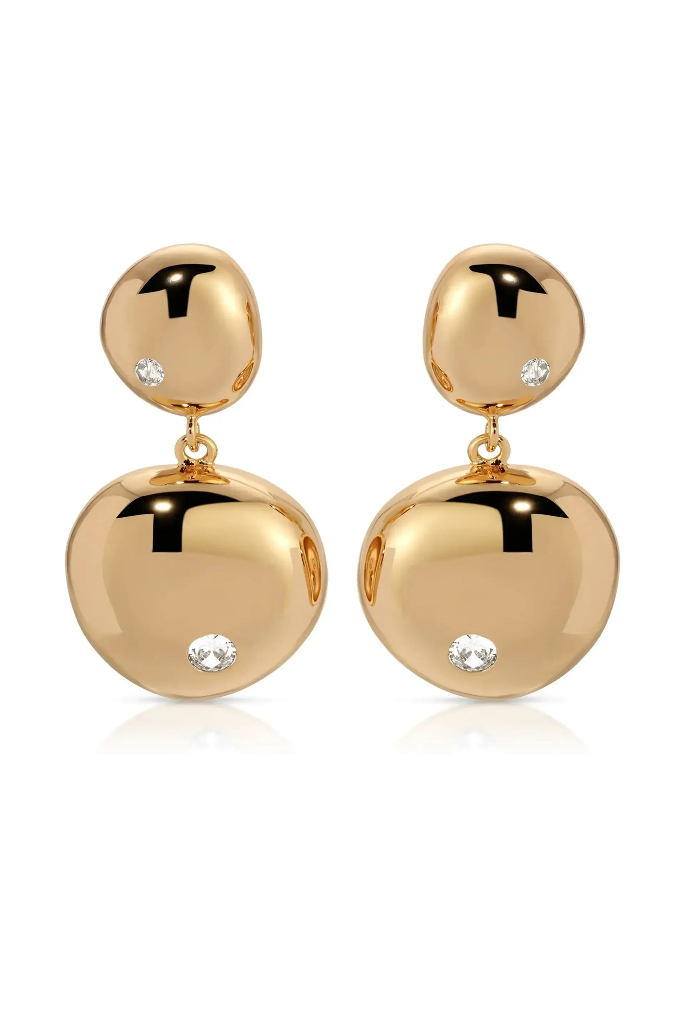Two gold earrings dangle elegantly, featuring polished, rounded shapes adorned with small, sparkling diamonds. They rest on a white surface, reflecting light and enhancing their luxurious appearance.