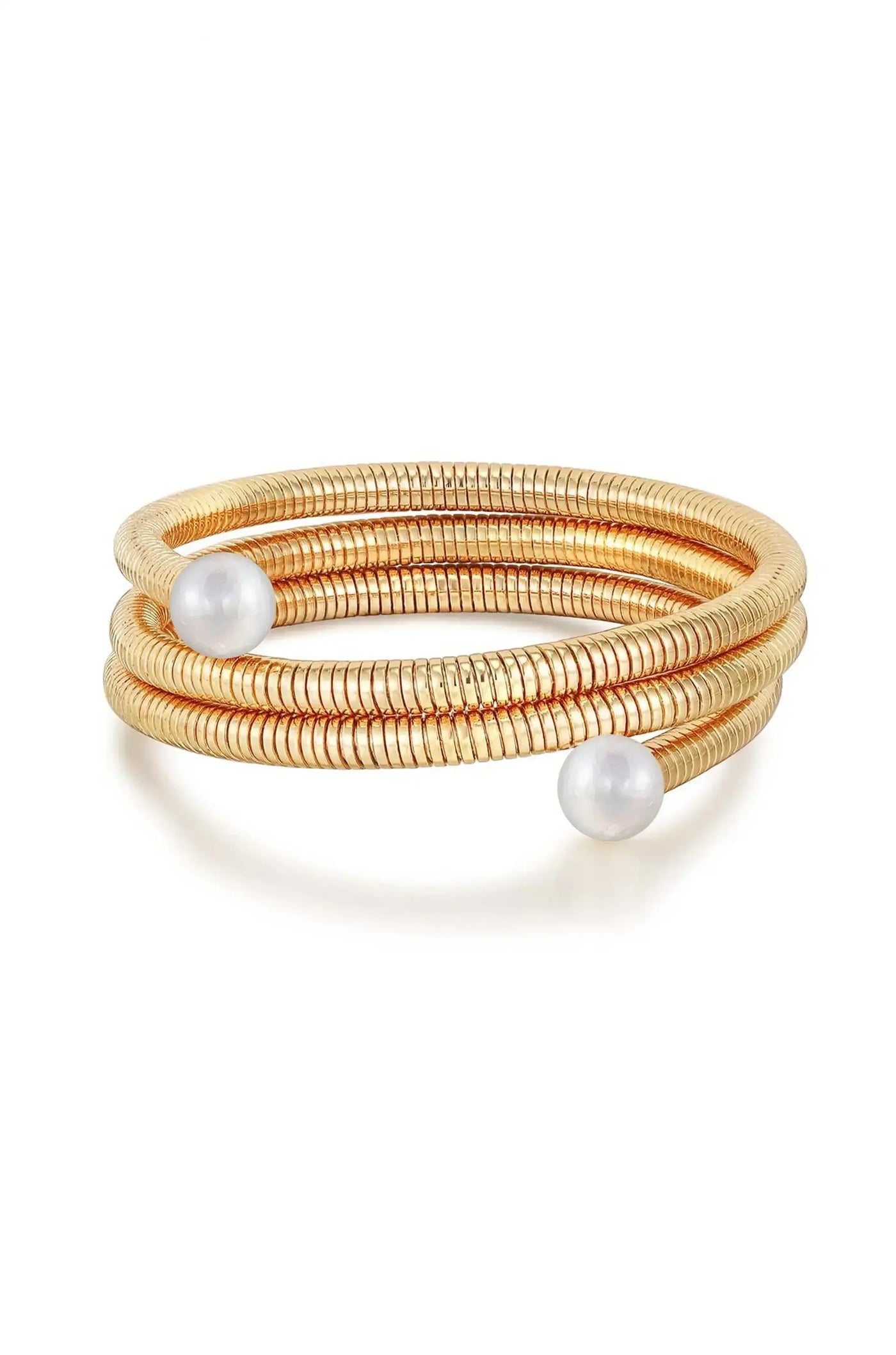 A spiral gold bracelet with a coiled design features two white pearls, elegantly placed. The bracelet stands out against a plain white background, highlighting its shine and intricate details.