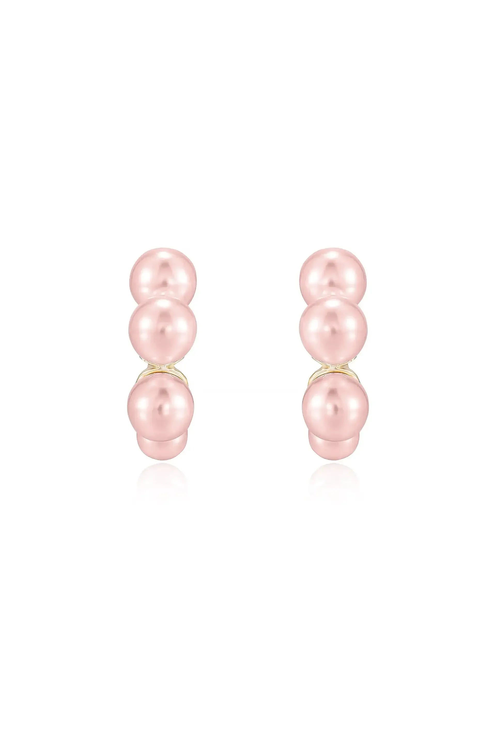 Two pairs of elegant pink pearl earrings are displayed, featuring three round pearls stacked vertically on a gold setting, set against a plain white background.