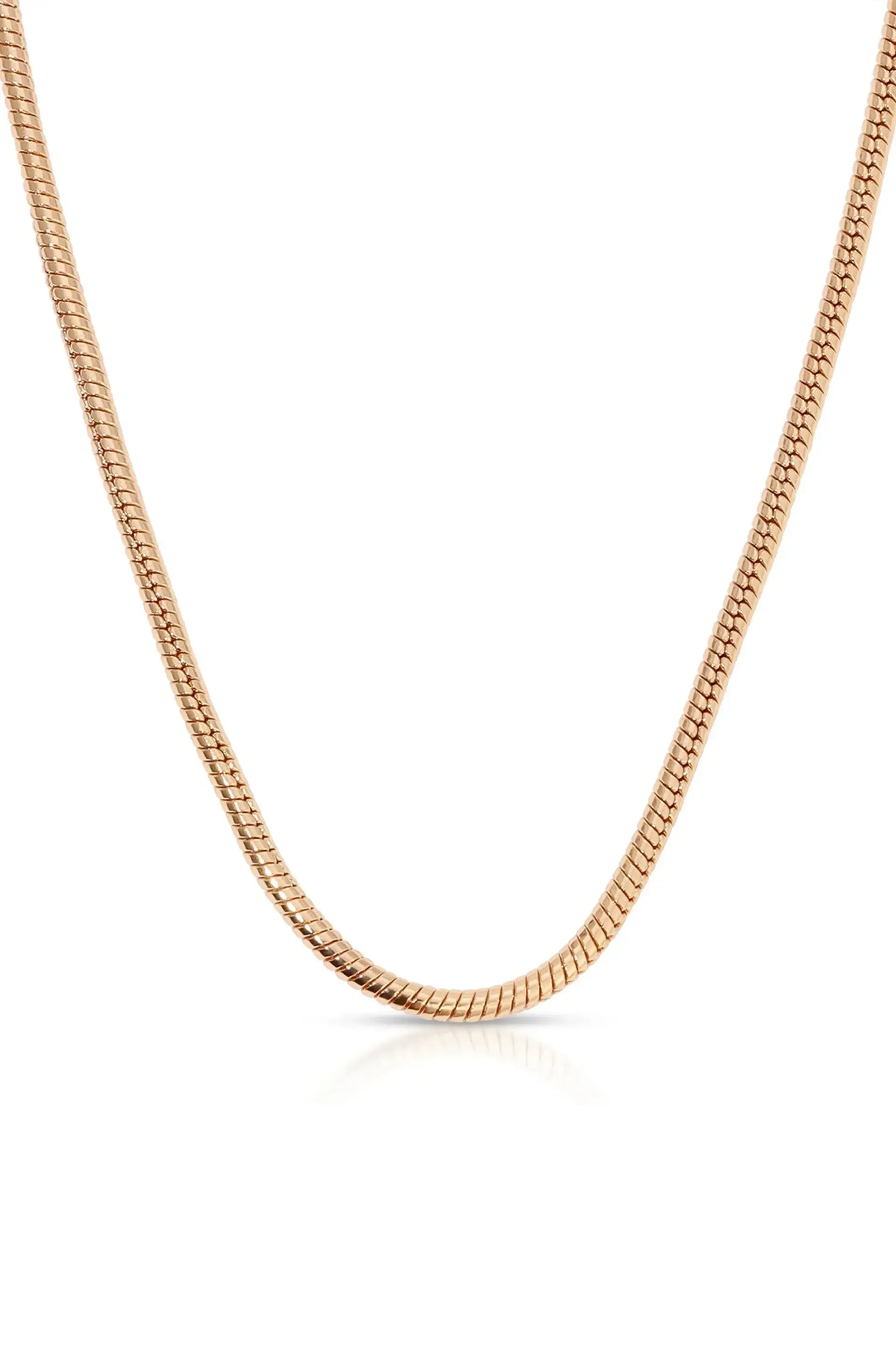 A shiny, rose gold chain rests against a reflective surface, depicting a smooth, flexible design that demonstrates elegance and simplicity in jewelry.