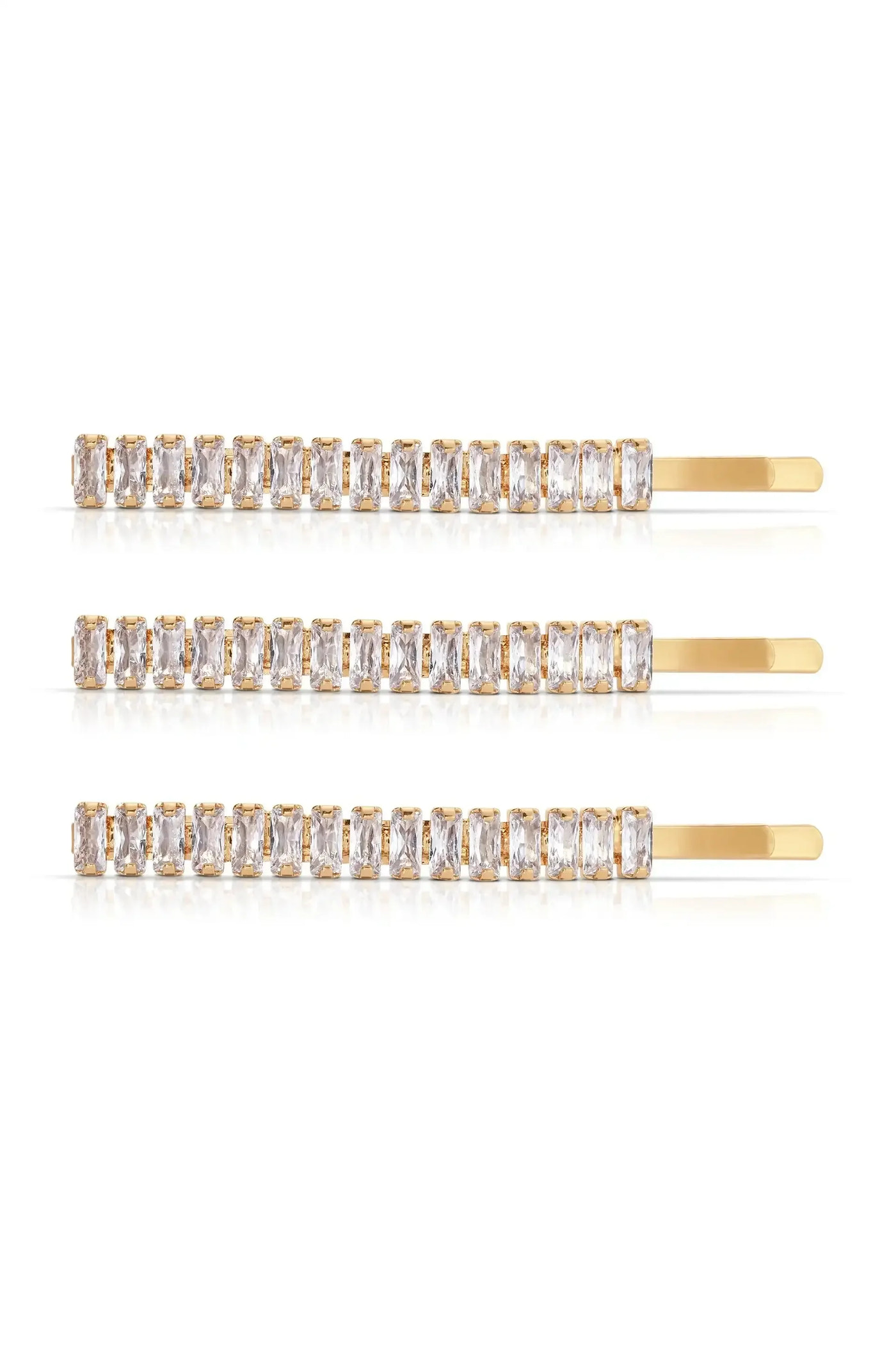Three gold hairpins adorned with rectangular, clear gemstones are arranged horizontally against a white background, reflecting light and showcasing their elegant design.