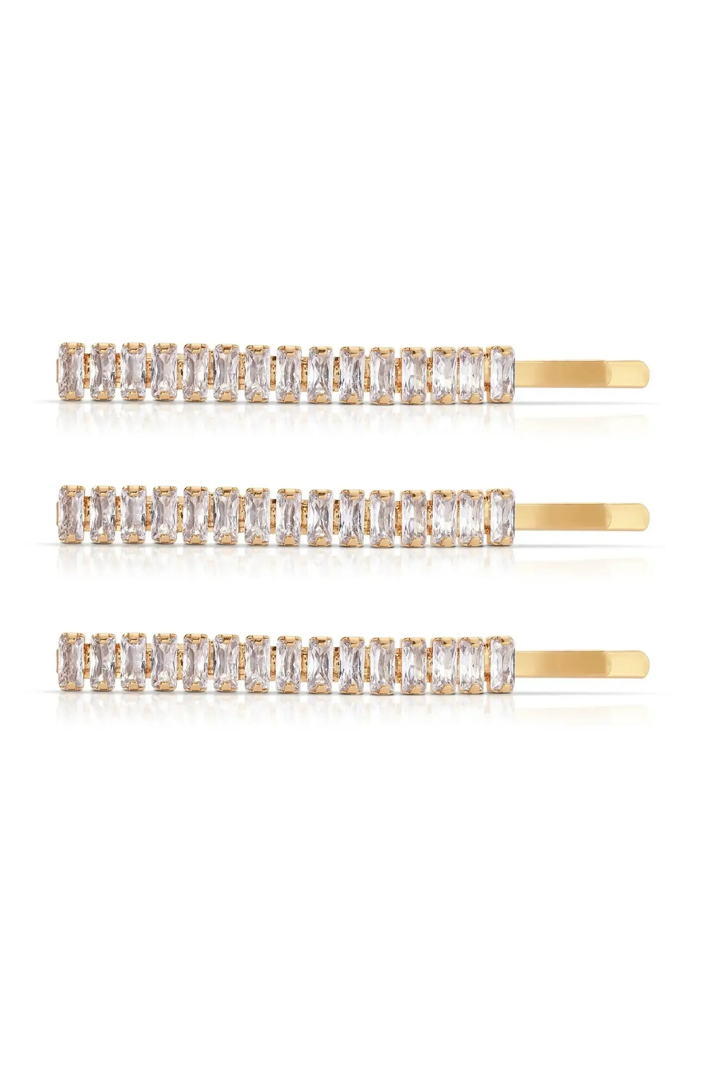 Three gold hairpins adorned with rectangular, clear gemstones are arranged horizontally against a white background, reflecting light and showcasing their elegant design.