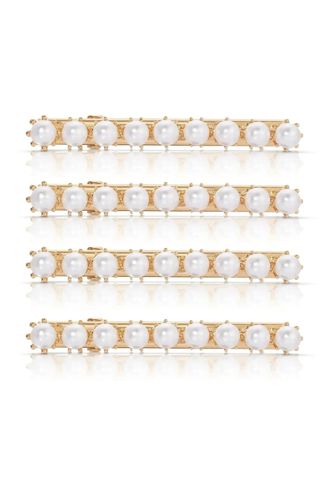 A set of four gold hairpins adorned with alternating white pearls and small decorative elements reflect light on a smooth surface, emphasizing their elegance and design.