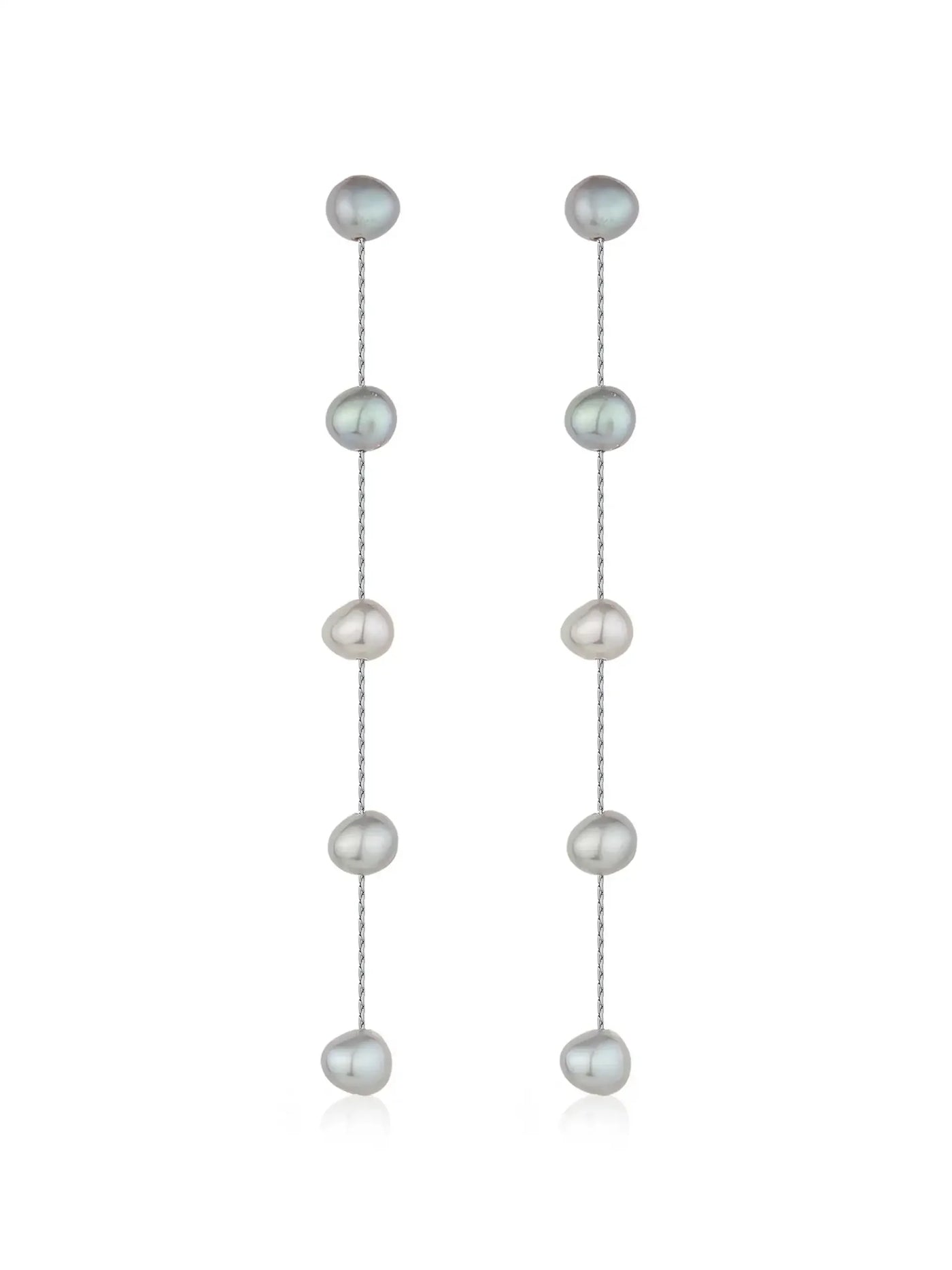 Dangling earrings composed of alternating, glossy, irregularly shaped pearls in muted shades of gray and white are suspended from a delicate silver chain against a plain white background.