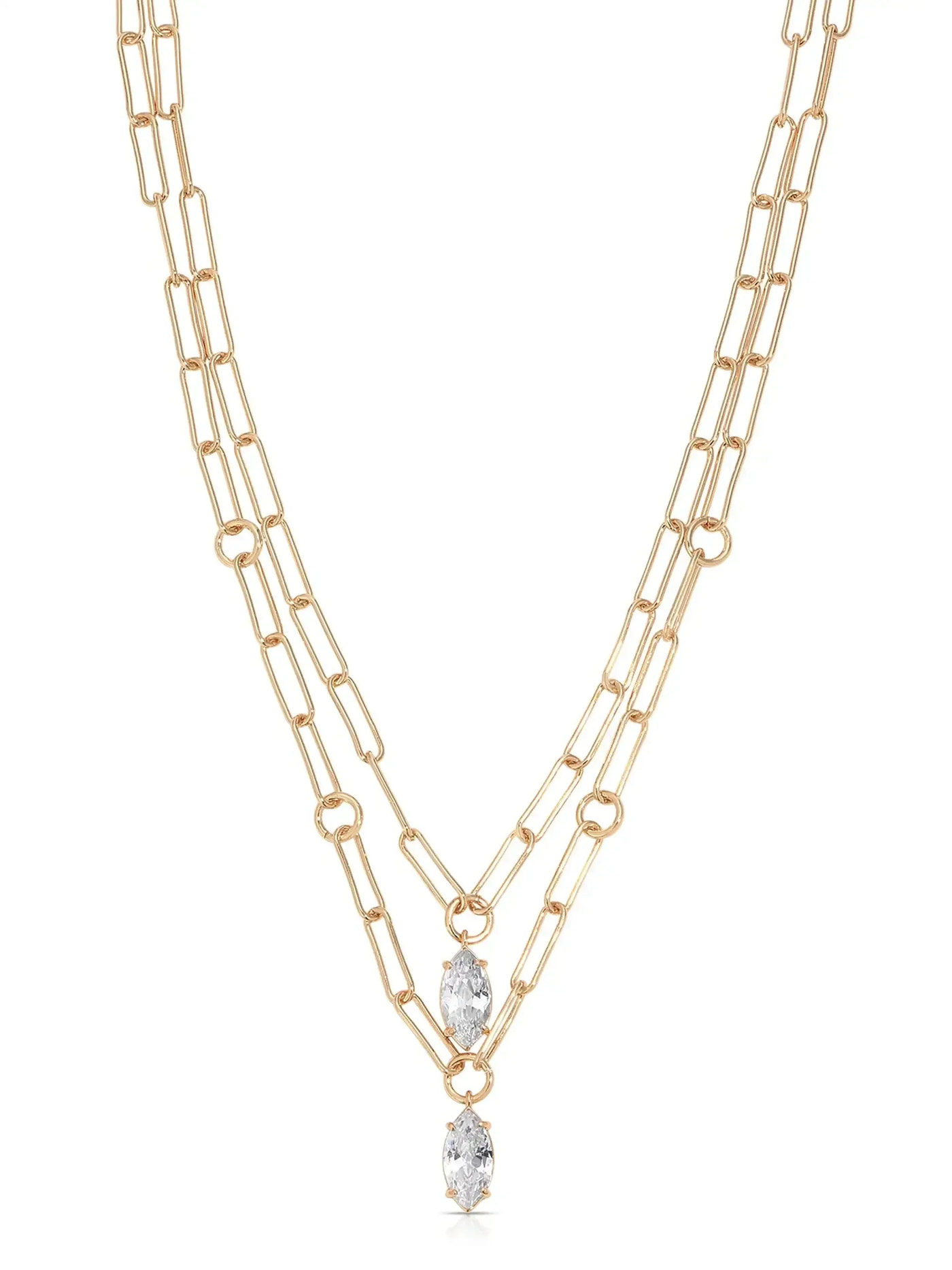 A gold chain necklace features two layered strands with elongated links. At the center, two marquise-cut crystals dangle, enhancing the jewelry's elegance against a neutral background.