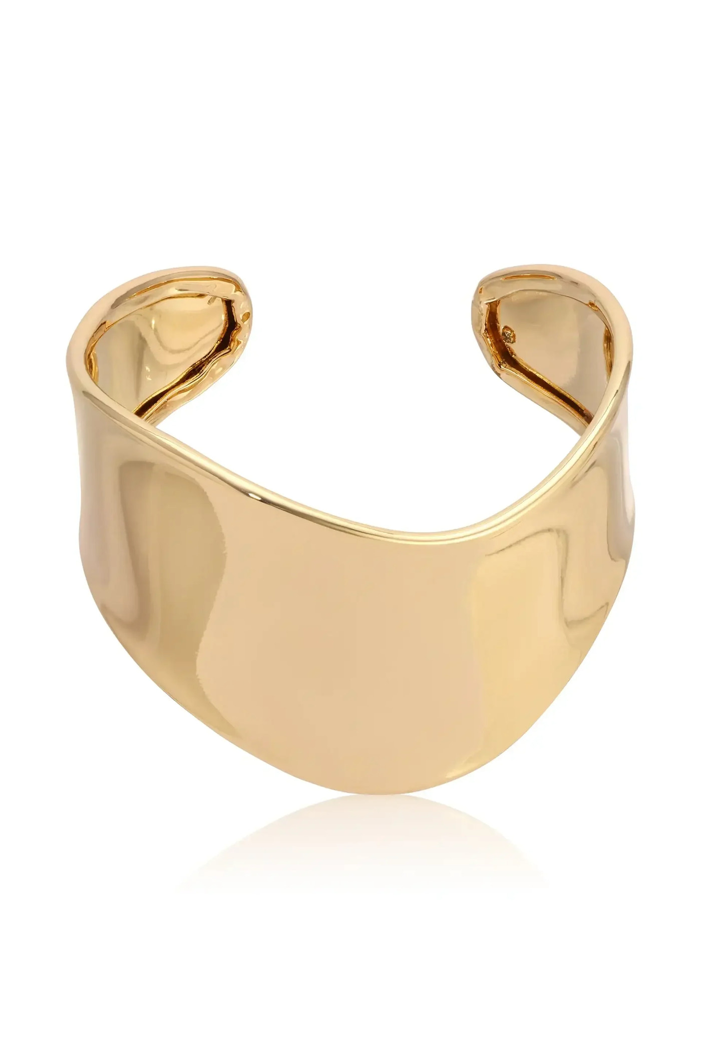 A shiny, golden cuff bracelet is shown, resting on a smooth reflective surface. Its sleek, curved design features open ends, emphasizing modern elegance. The background appears neutral and unobtrusive.