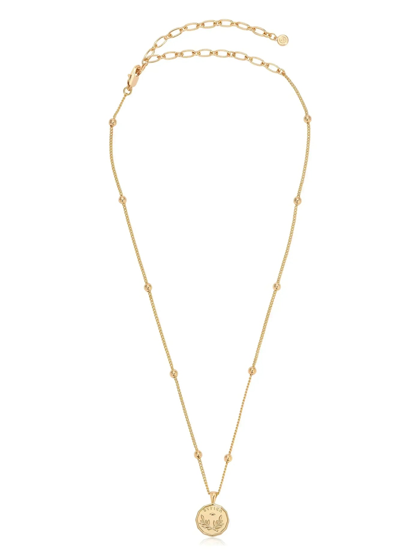 A delicate gold necklace features a circular pendant at the center. The chain consists of fine links and small beads, set against a neutral background, suggesting elegance and simplicity.