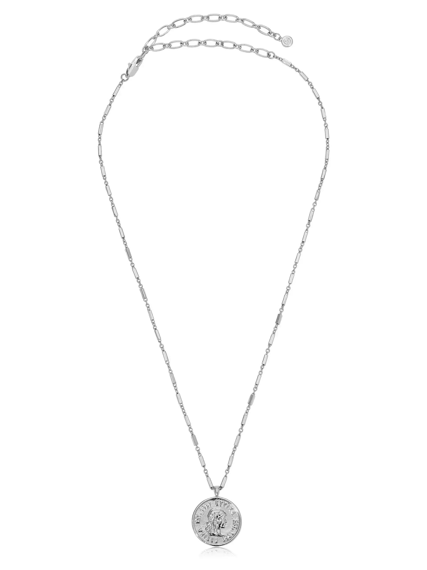 A silver chain necklace features a circular pendant displaying an embossed image. The necklace is elegantly arranged, reflecting light in a minimalist setting.